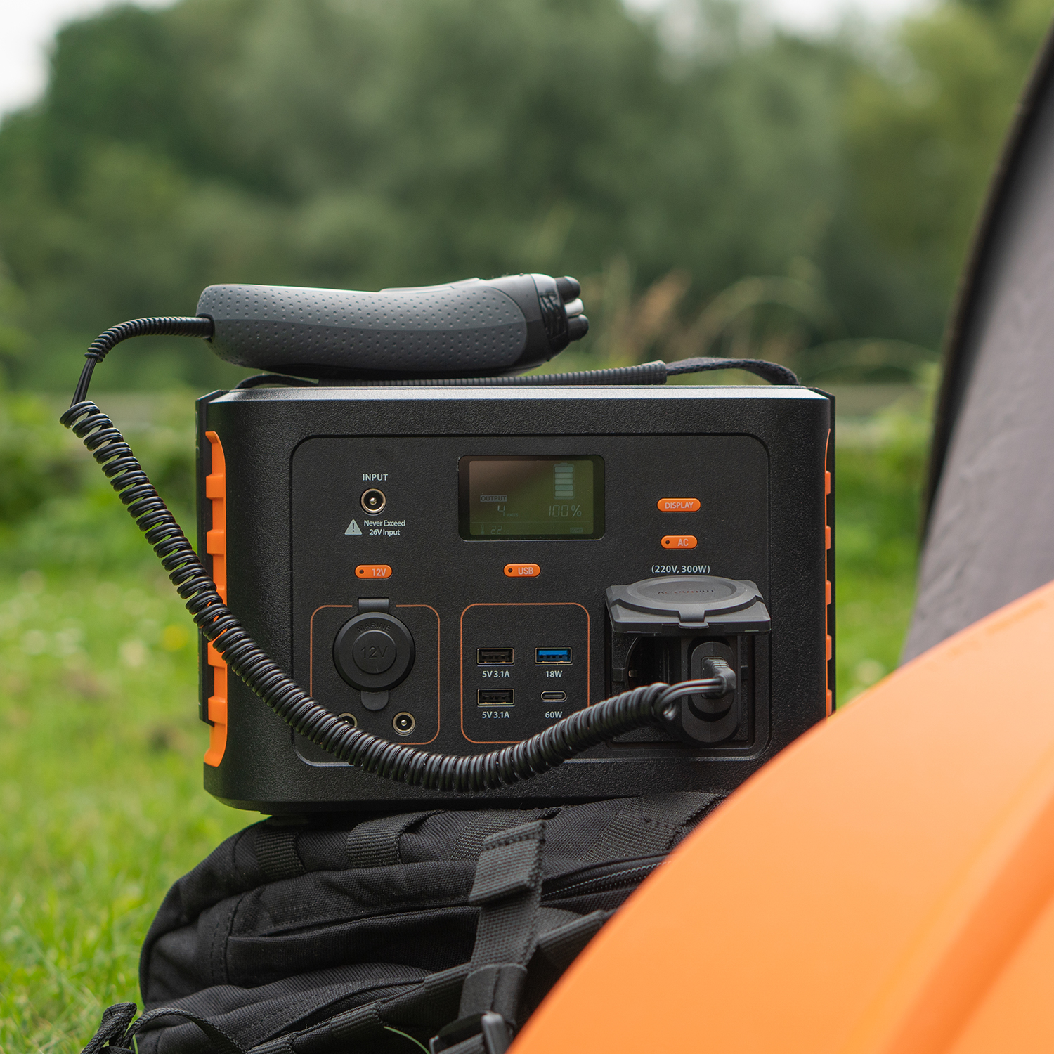 Schwarz-orange Powerstation mit angeschlossenem Ladegerät.