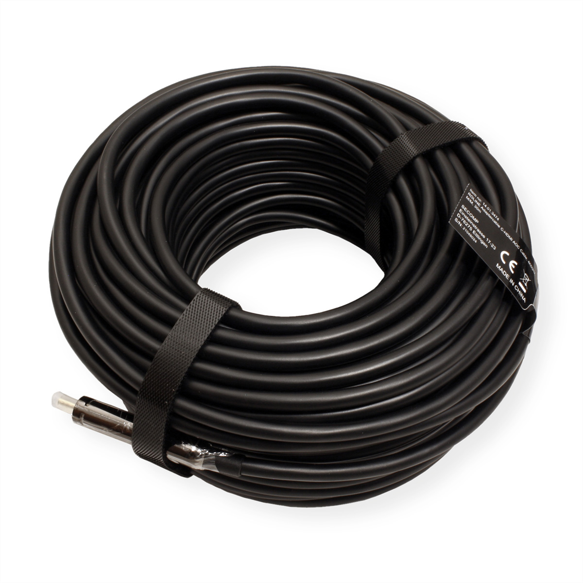 Un cable negro enrollado, asegurado por una correa negra. El cable está sobre una superficie blanca.