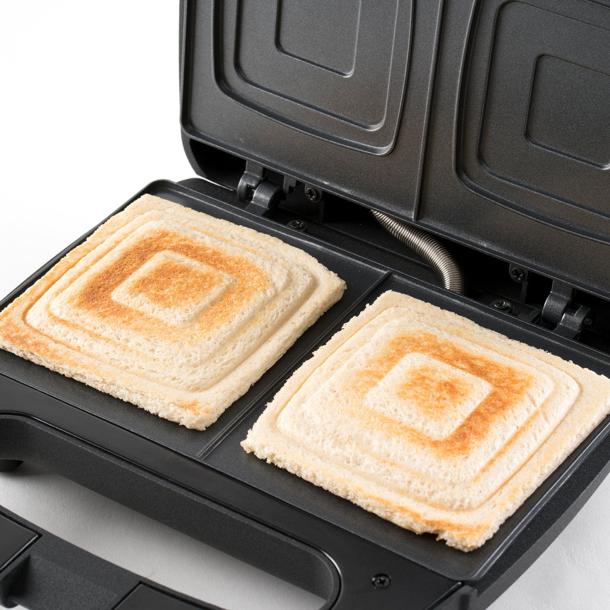 Toster do kanapek z dwoma tostami, kwadratowe wzory na jasnym tle.