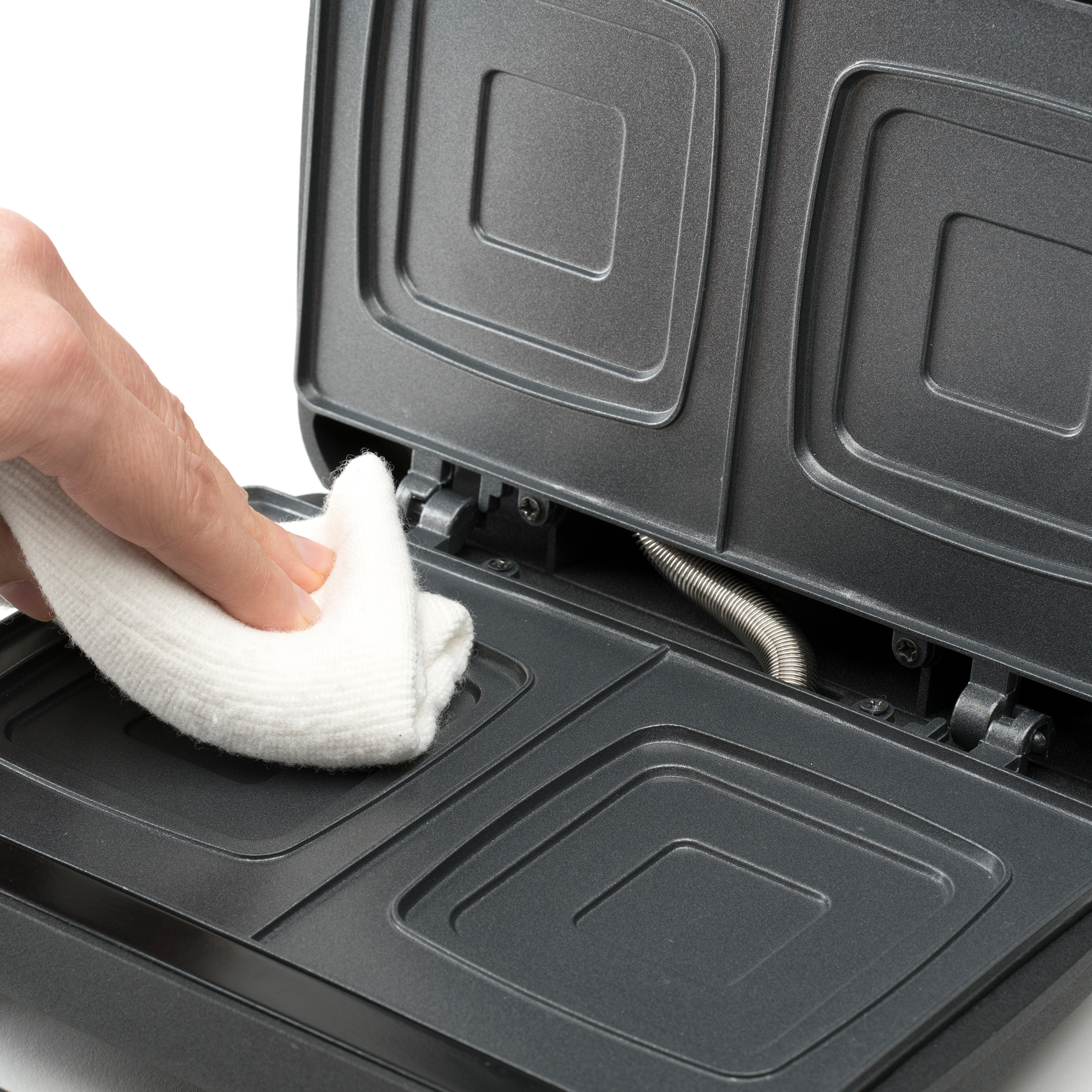 Osoba czyszcząca opiekacz do kanapek białą szmatką, zbliżenie.