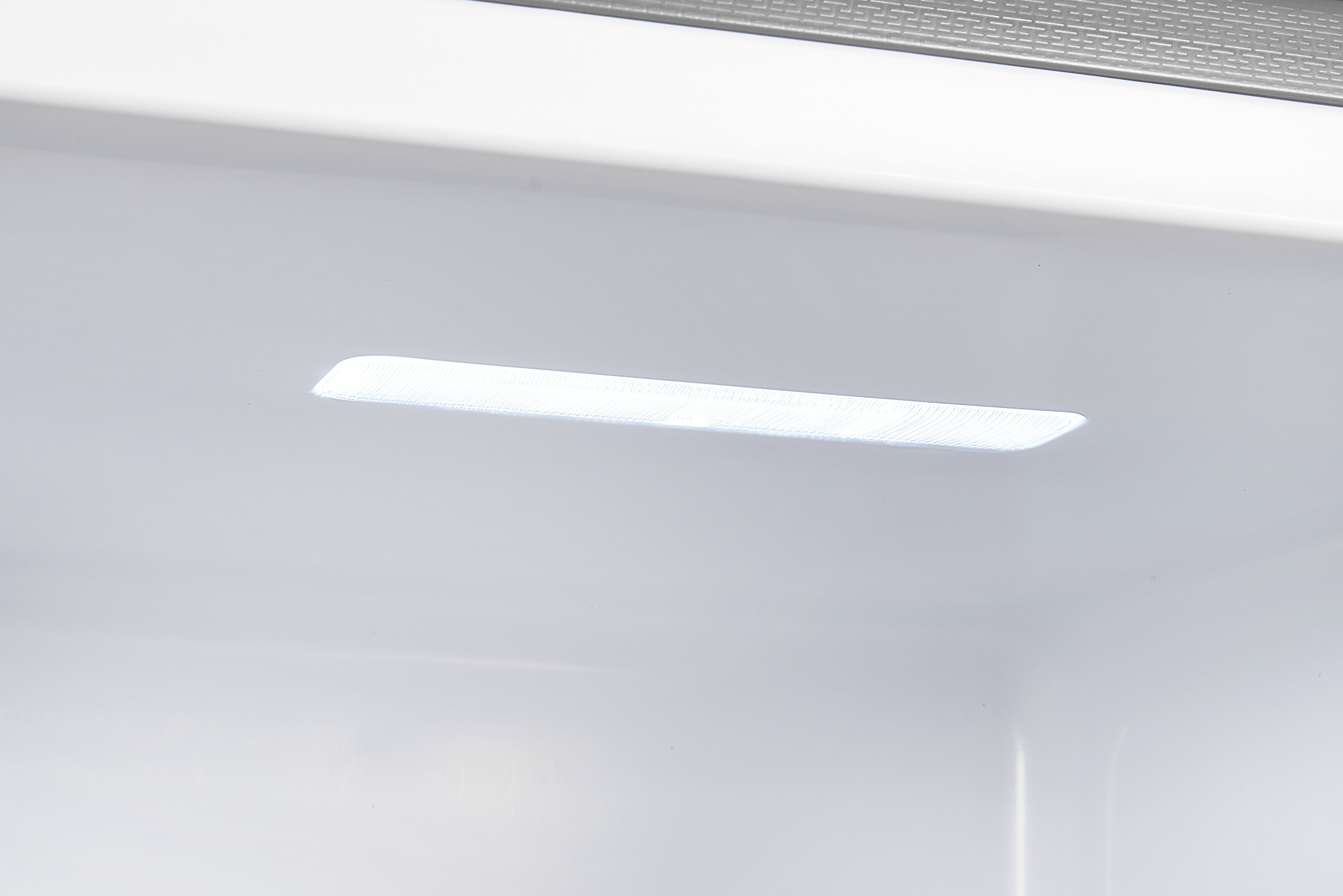 Weißer Kühlschrankinnenraum mit hellem Licht. Einfaches und sauberes Design. Weißer Hintergrund.