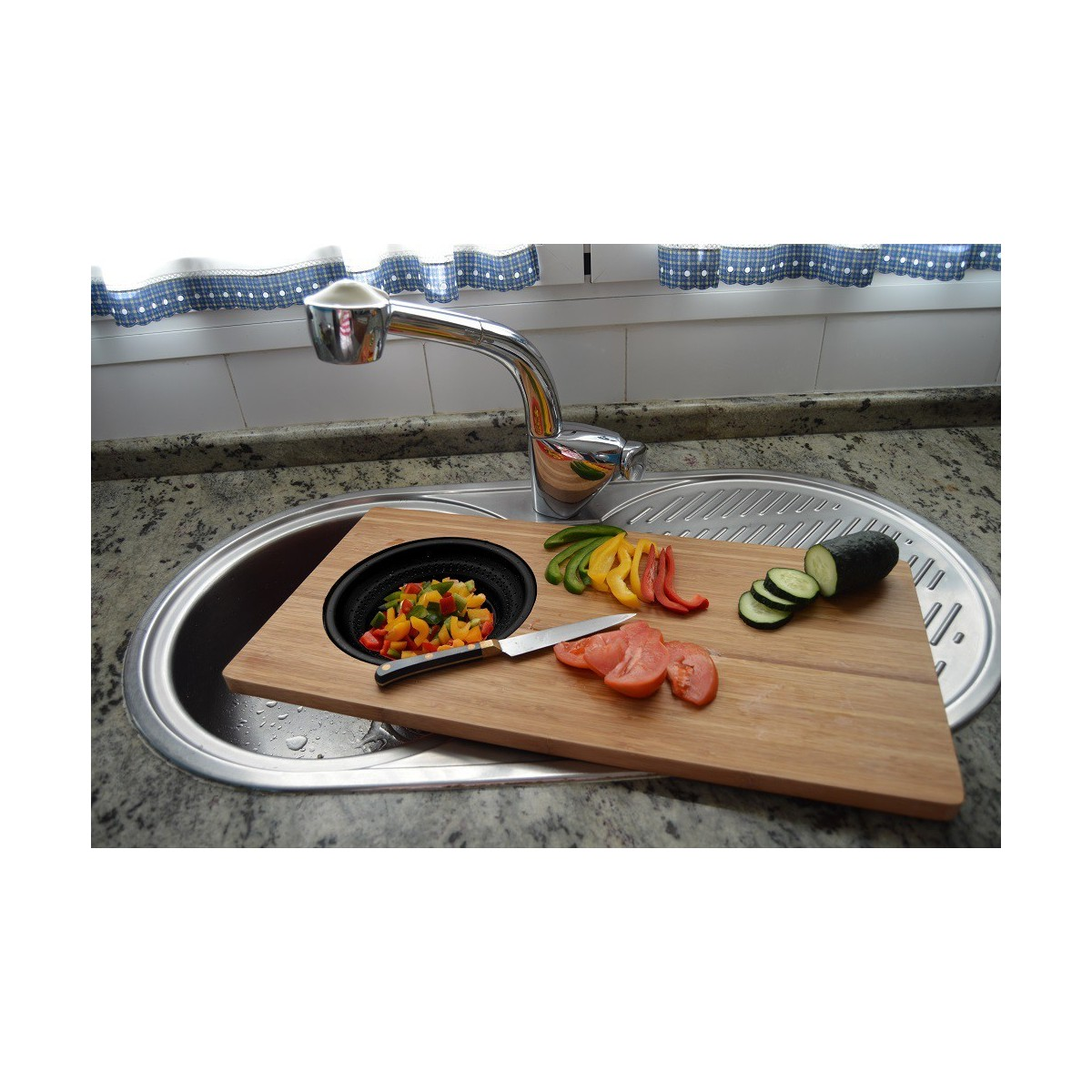 Un fregadero de cocina con una tabla de cortar, verduras y un cuchillo. El grifo es visible.
