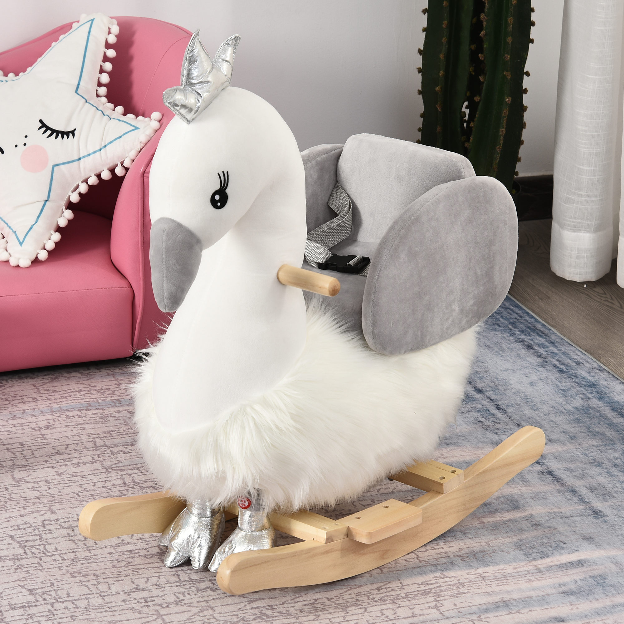 Un balancín de cisne blanco con corona y pies plateados sobre balancines de madera.