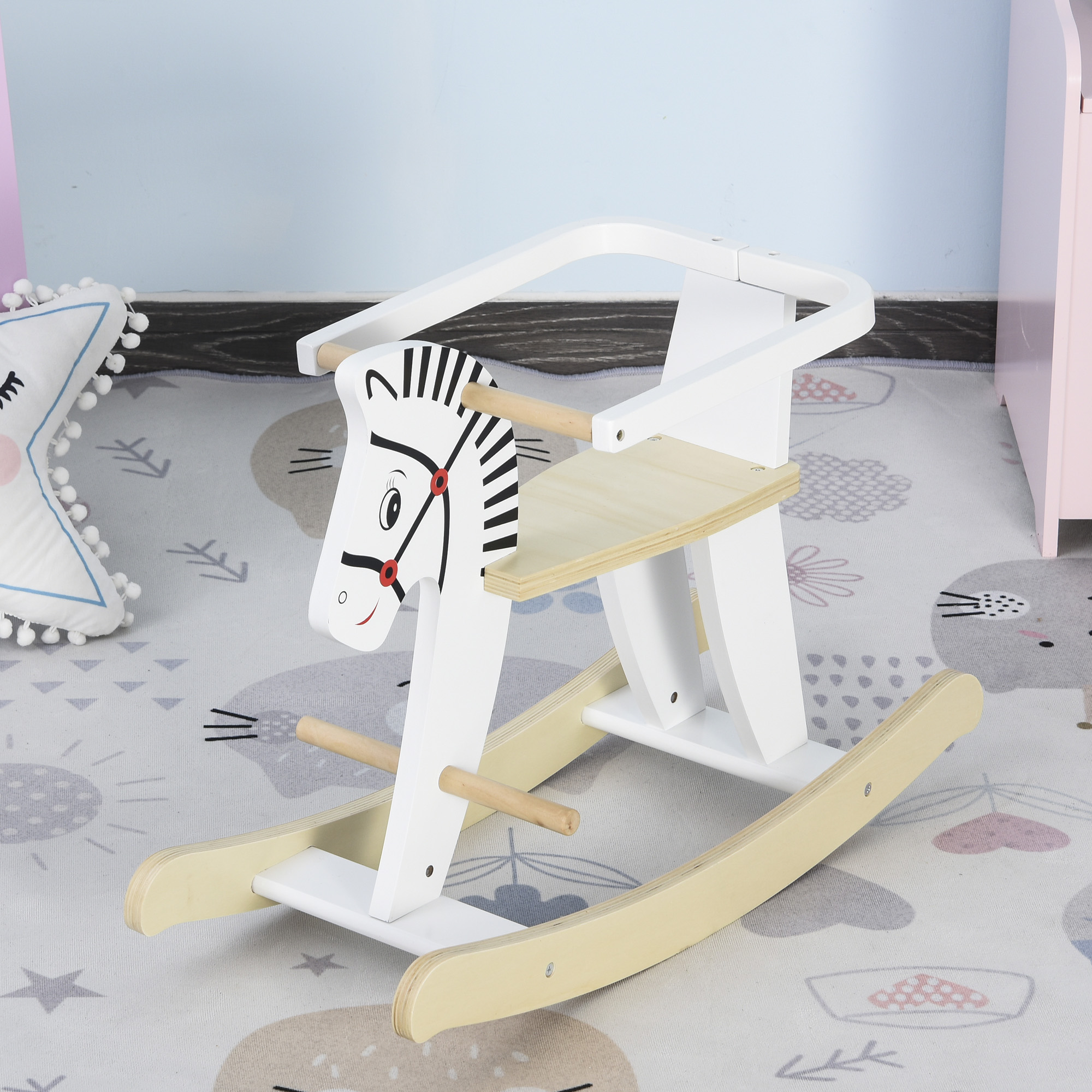Un cavallo a dondolo in legno bianco con un design a testa di cavallo su un tappeto fantasia.