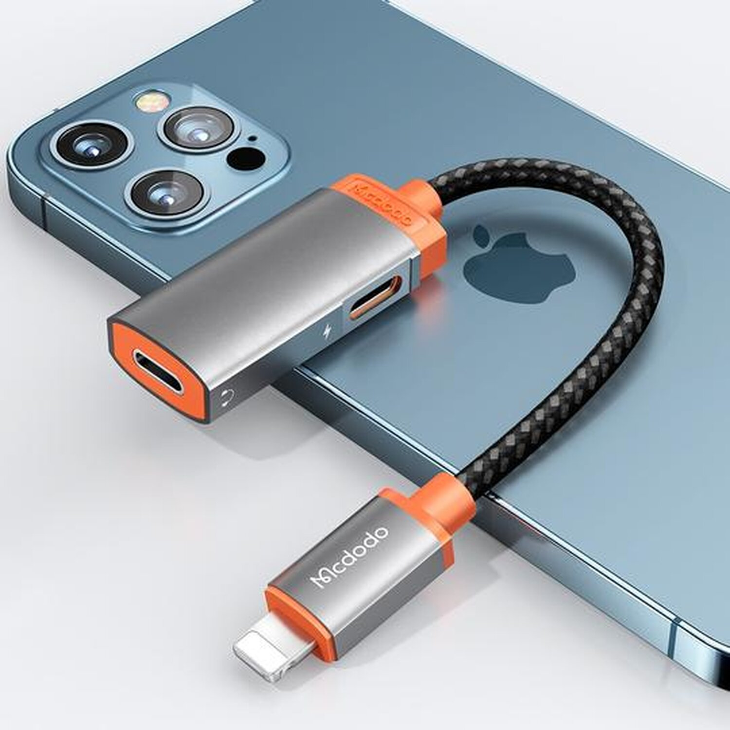 Ein silberner und oranger Telefonadapter ist an ein blaues Telefon angeschlossen. Ein schwarzes geflochtenes Kabel verbindet sich mit dem anderen Ende.