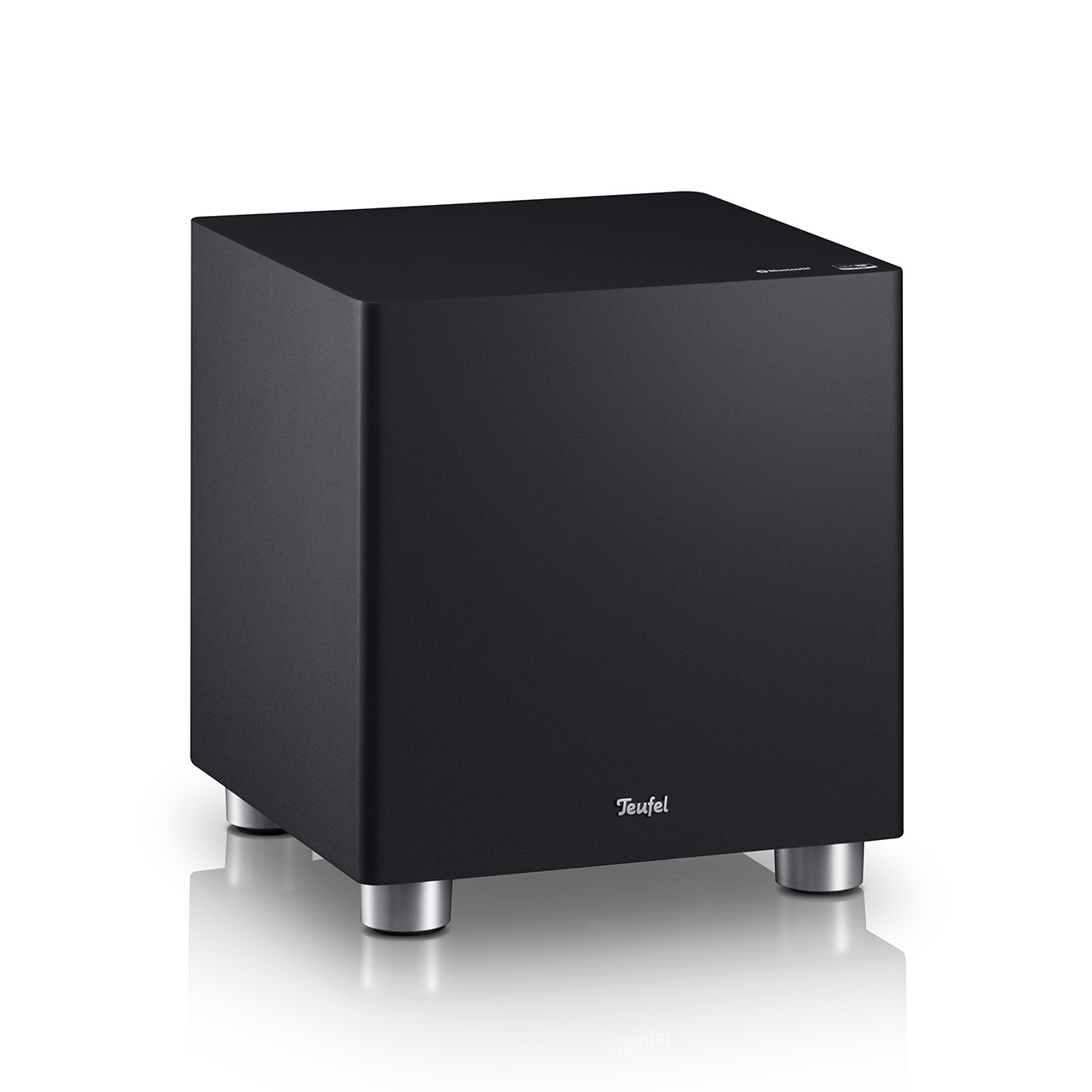 Ein schwarzer Subwoofer auf silbernen Beinen auf einer weißen Oberfläche. Der Markenname ist Teufel.