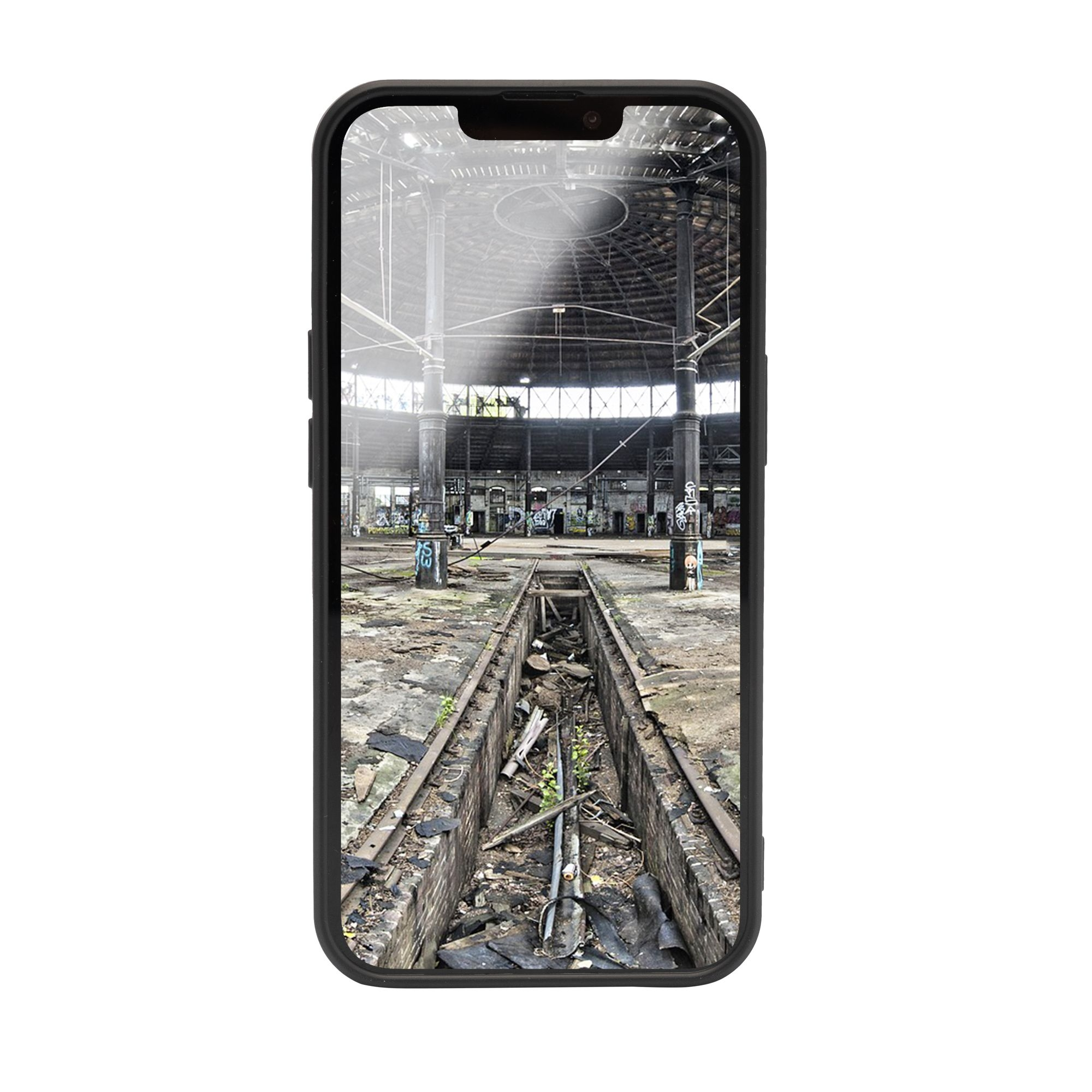 Telefono che mostra un interno industriale, con pavimento danneggiato e dettagli architettonici.