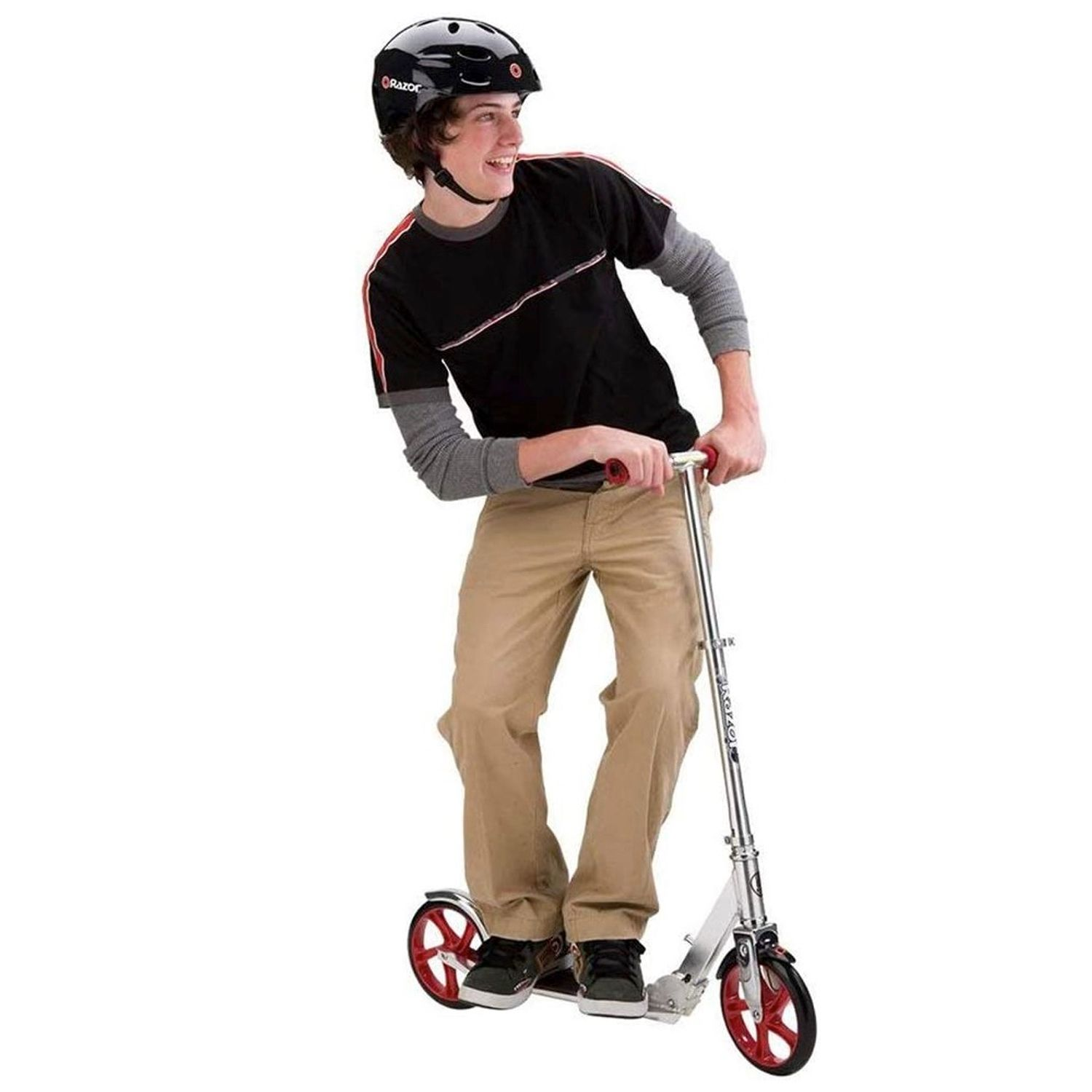 Chłopiec na hulajnodze. Ma na sobie kask i spodnie khaki. Białe tło.