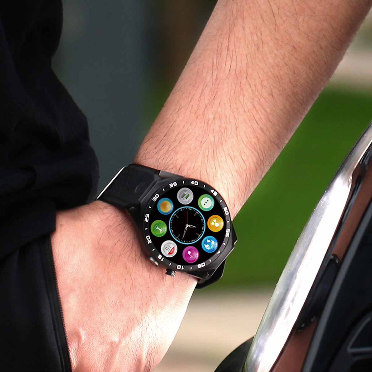 Polso di uomo con uno smartwatch nero che mostra varie icone di app.
