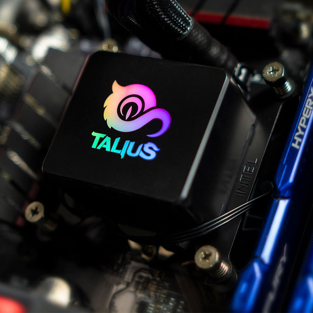 Czarny cooler procesora TALIUS z kolorowym logo, zainstalowany na płycie głównej komputera.