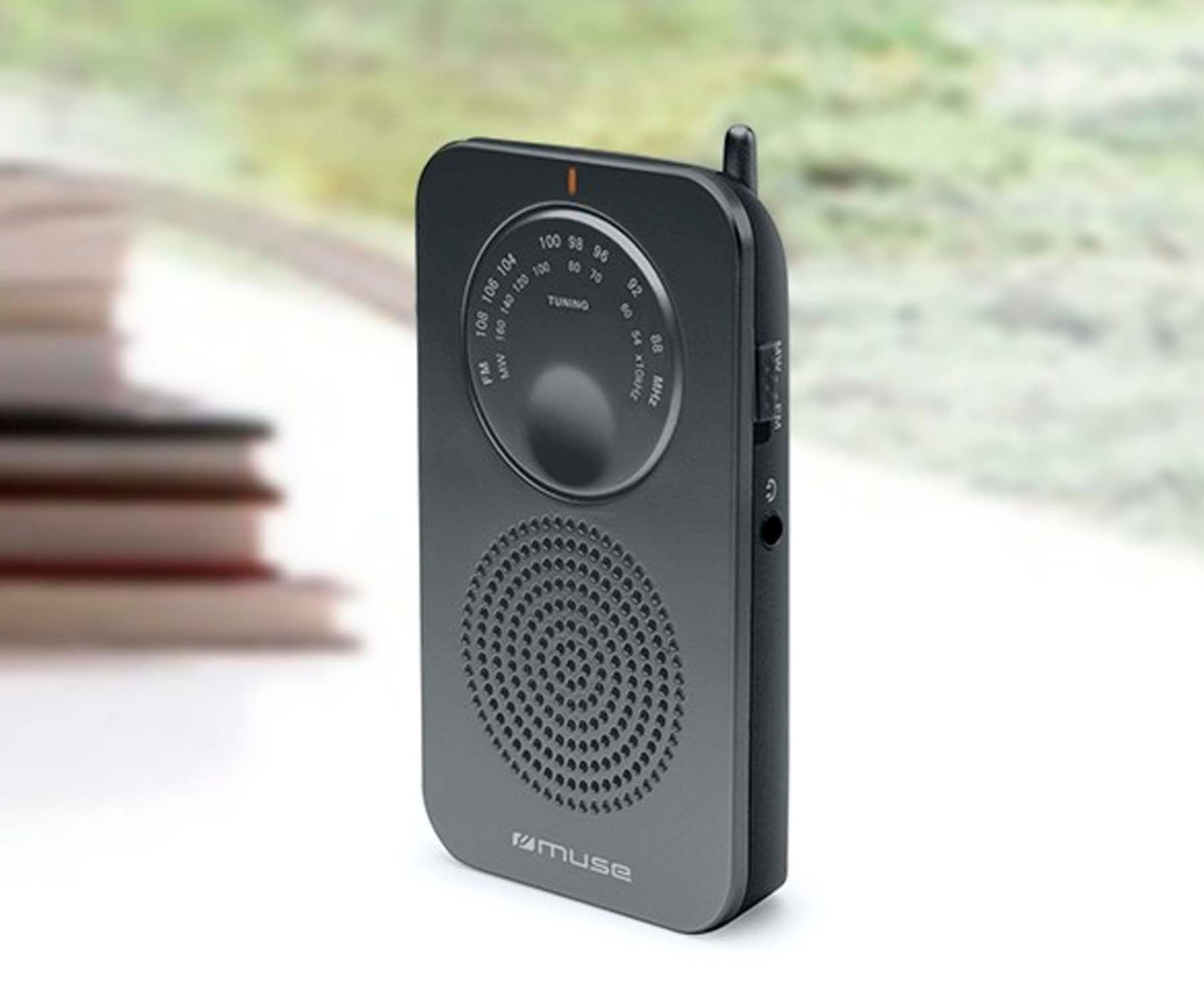 Czarne radio Muse z pokrętłem strojenia i głośnikiem. Znajduje się na stole z rozmytym tłem.
