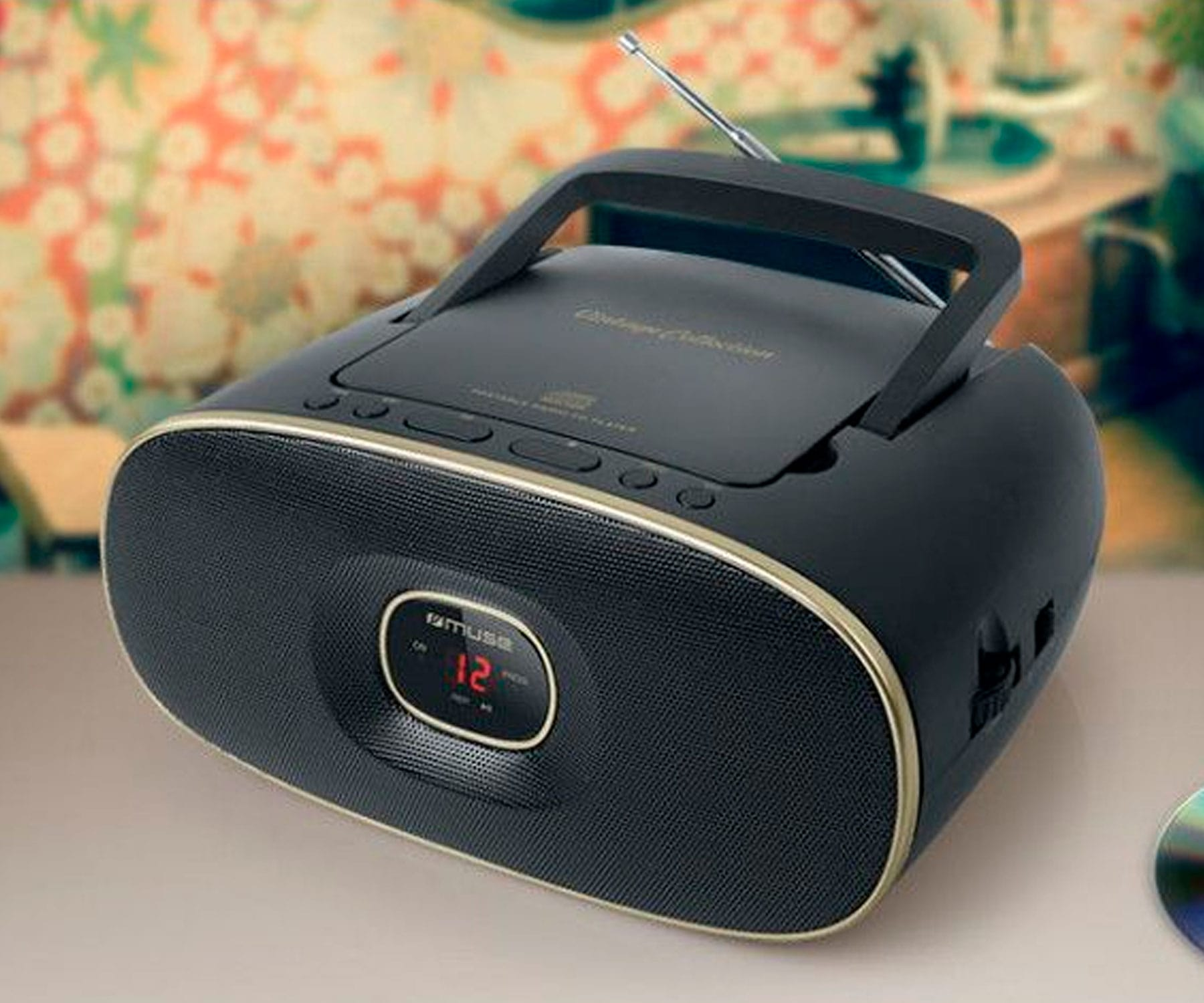 Radio-lettore CD nero in stile vintage con maniglia. Ha un display digitale e pulsanti.