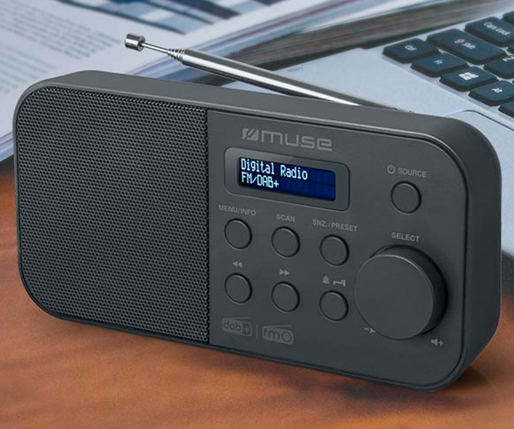 Ciemnoszare radio cyfrowe z przyciskami i wyświetlaczem pokazującym FM/DAB+.