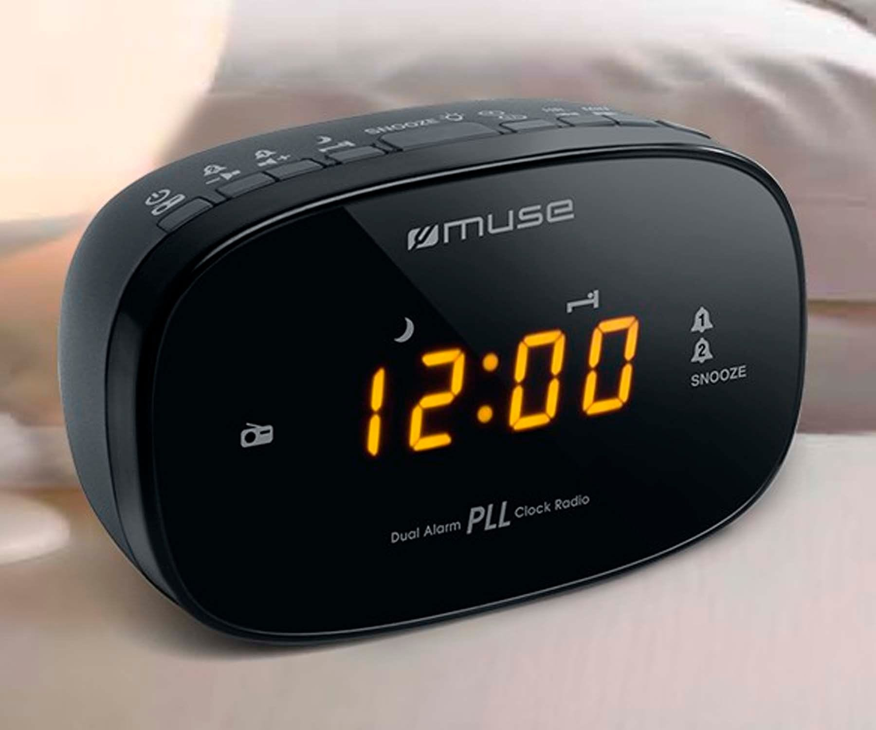 Black digital alarm clock with orange display showing 12:00. It has buttons and the brand 'muse'.