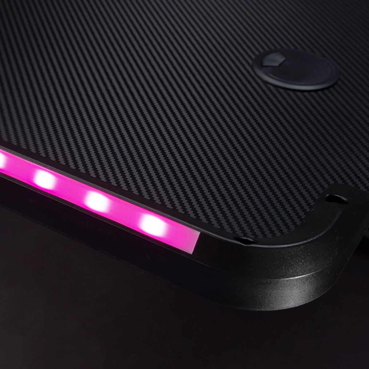 Esquina de escritorio negra con luces LED. La luz rosa emana del borde.