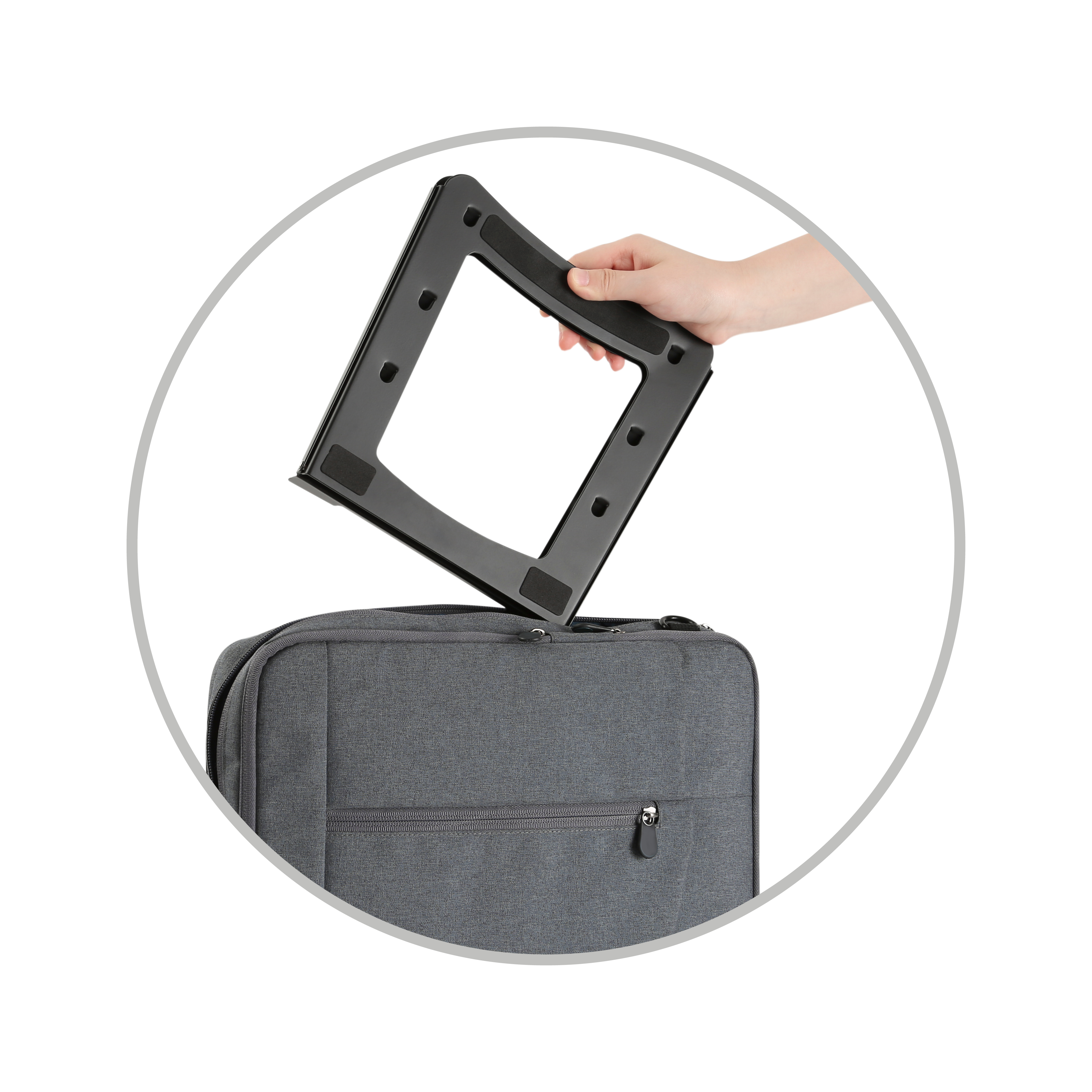 Una mano colocando un marco negro sobre una bolsa gris.