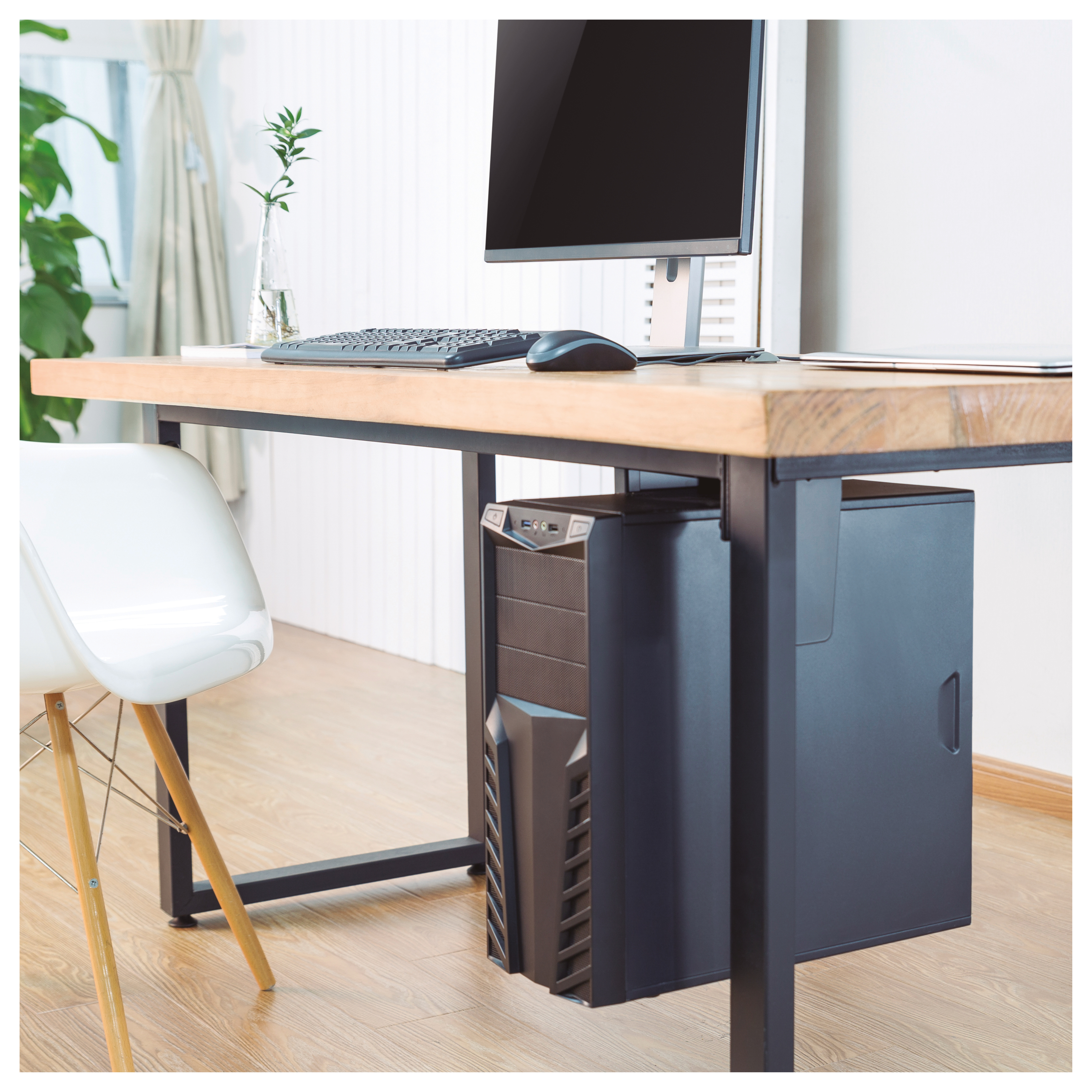 Un escritorio con una configuración de computadora, que incluye un monitor, teclado y ratón, con una torre debajo.