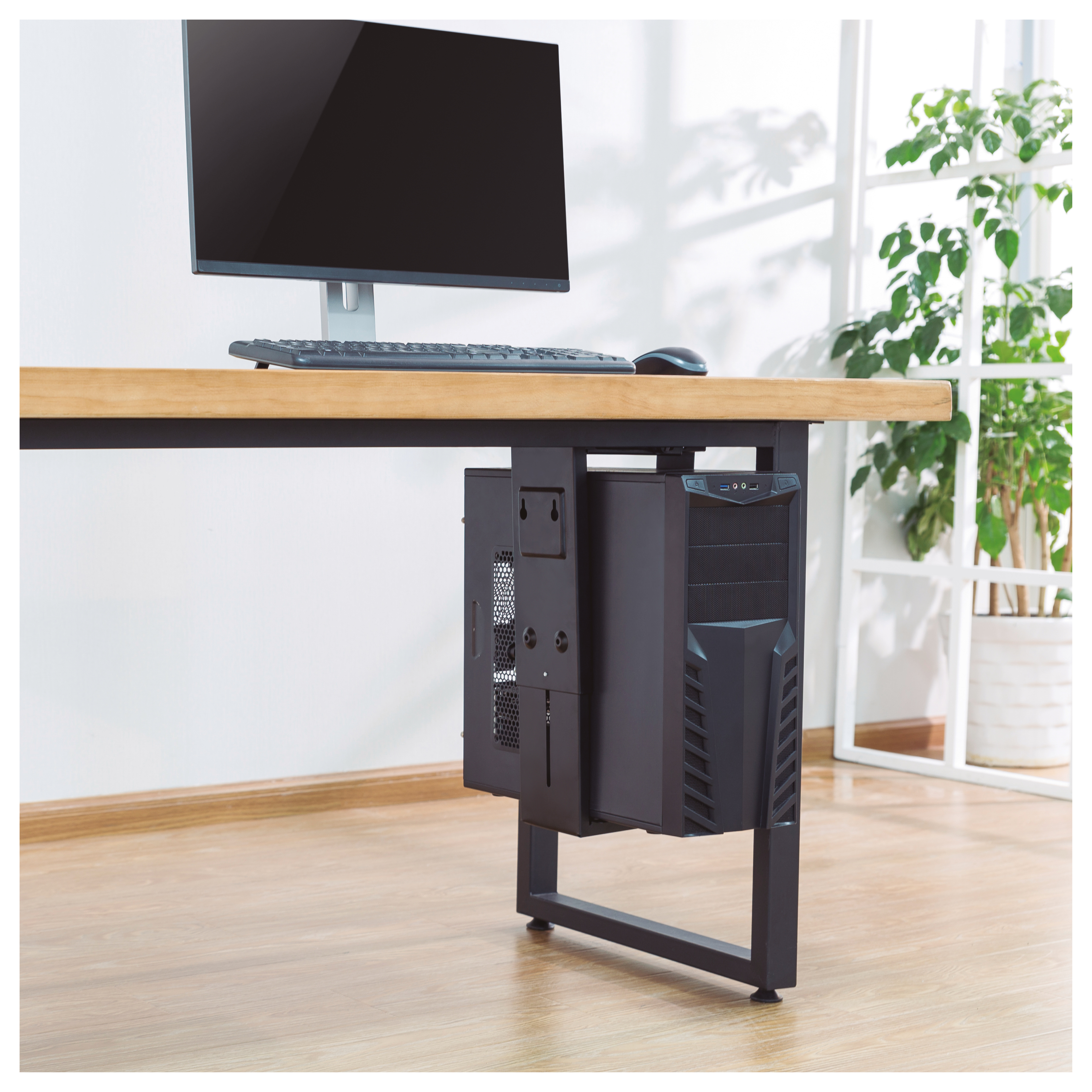 Una torre de computadora está montada en la parte inferior de un escritorio.