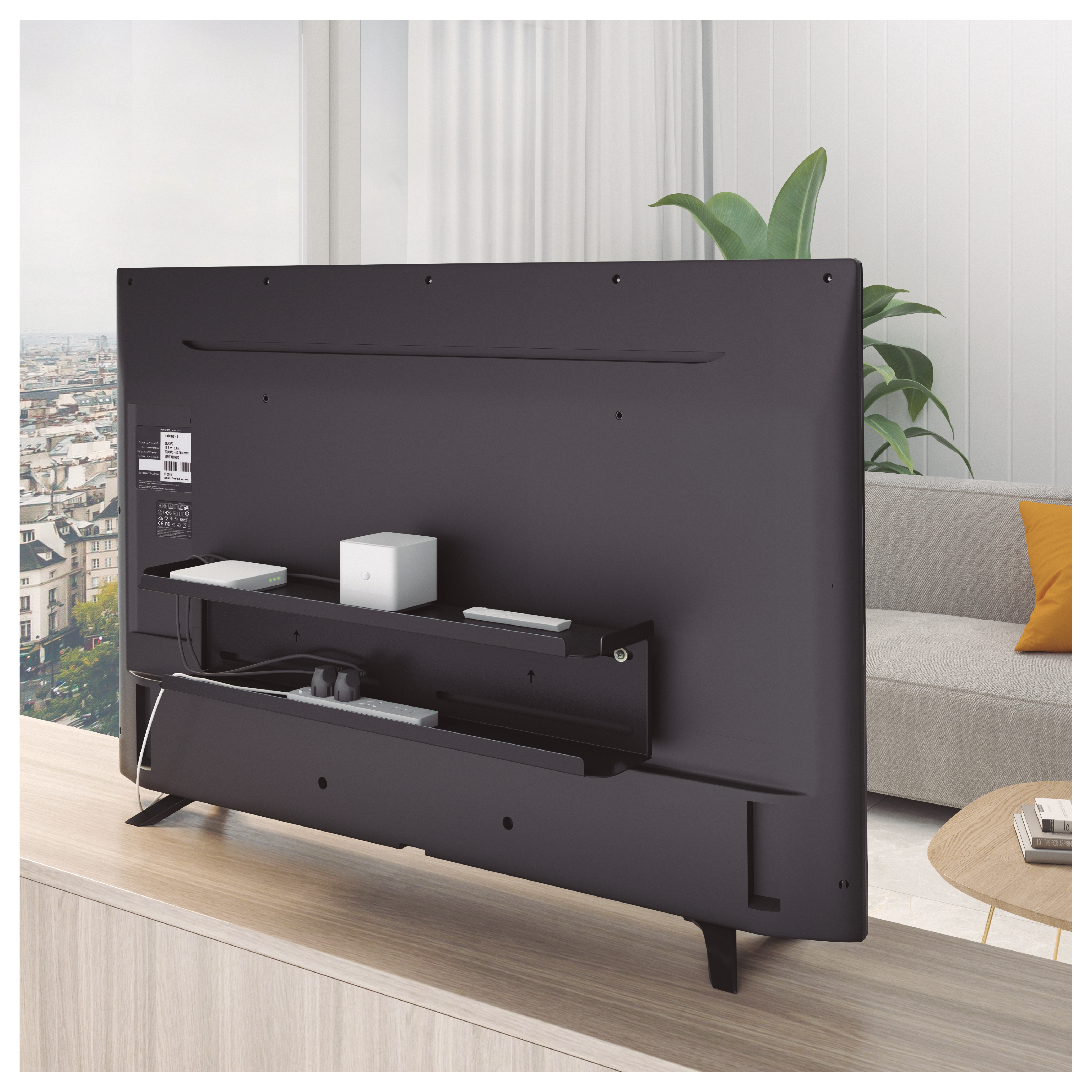 Parte trasera de TV con estante y gestión de cables. TV sobre superficie de madera.