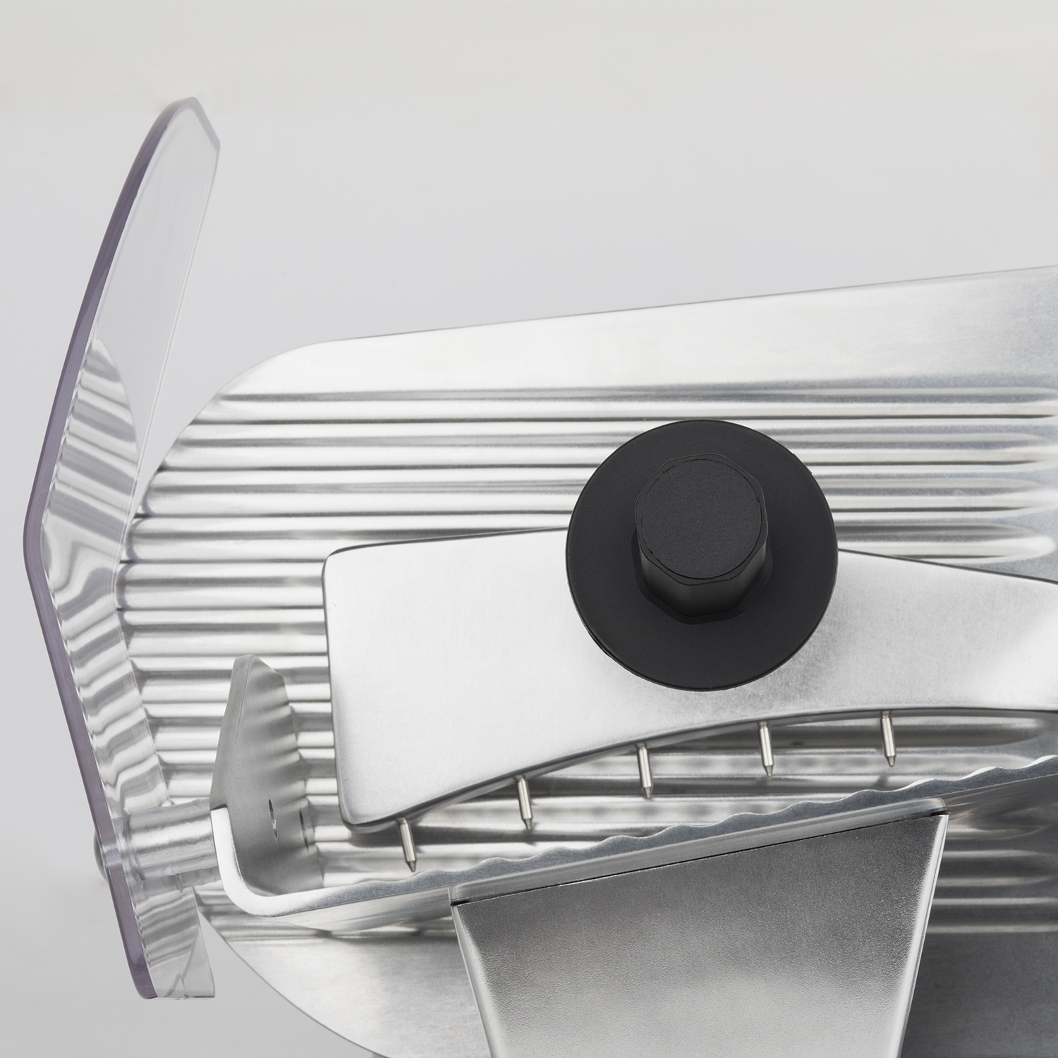 Zbliżenie krajalnicy do mięsa z przezroczystą osłoną ostrza.