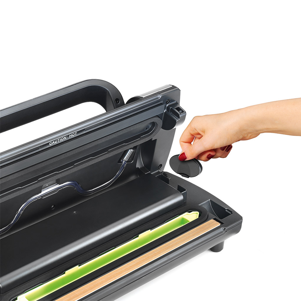 Ręka kobiety umieszczająca czarną pokrywę na czarno-szarej zgrzewarce próżniowej.