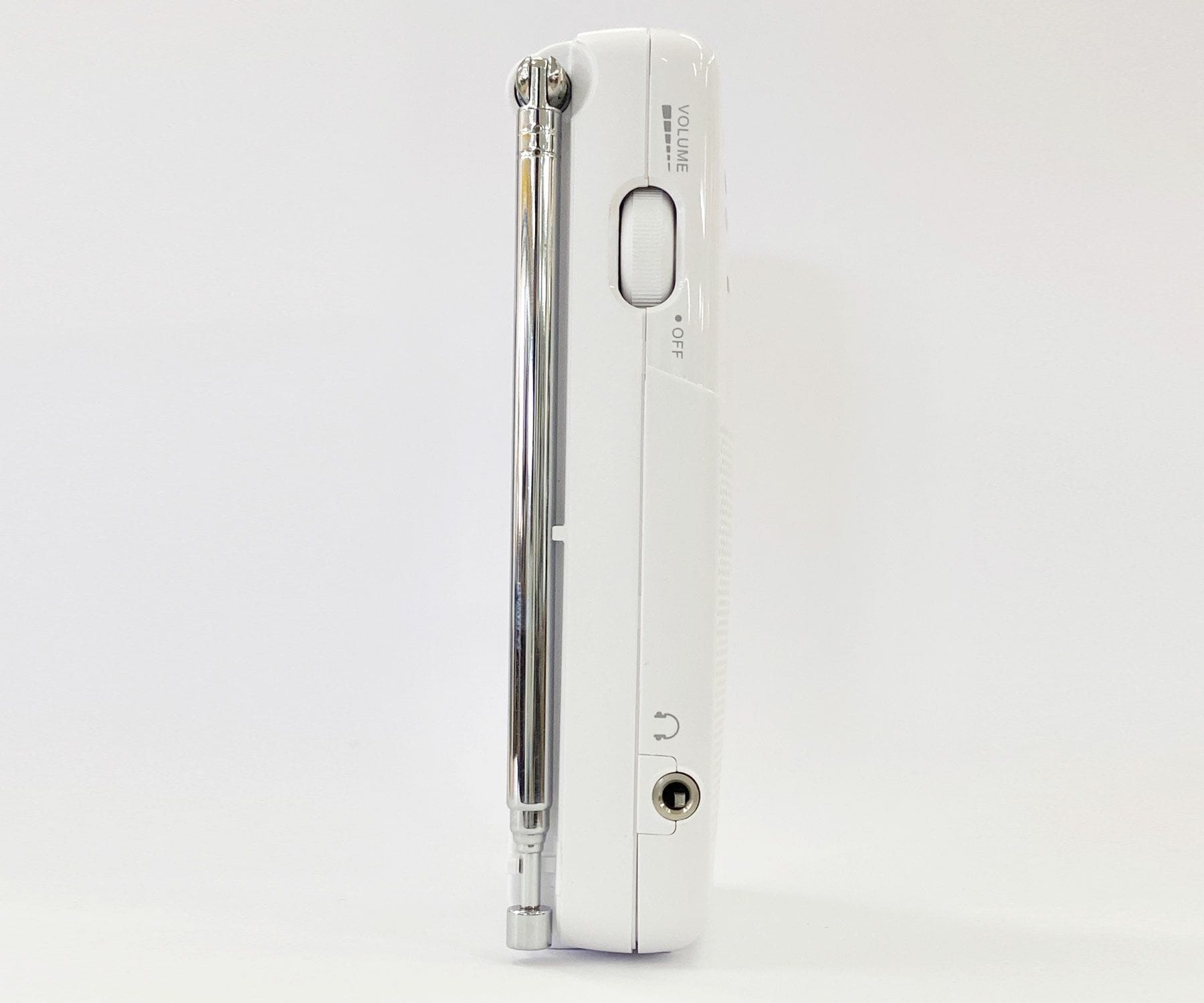 Białe radio przenośne z anteną i regulacją głośności na białym tle.