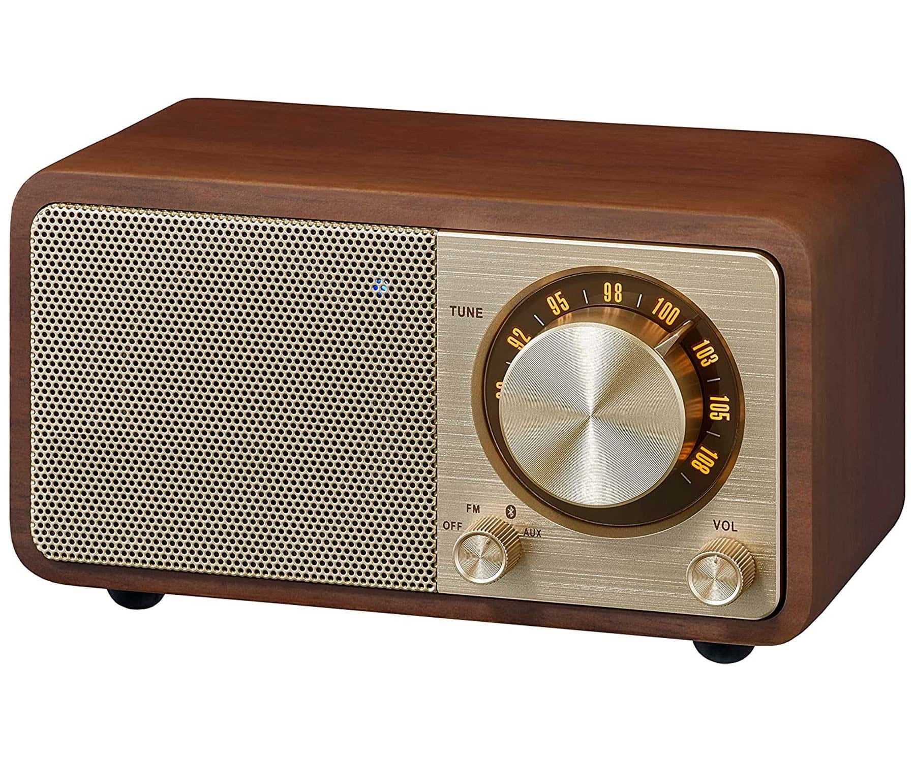 Drewniane radio retro ze złotymi detalami. Białe tło.