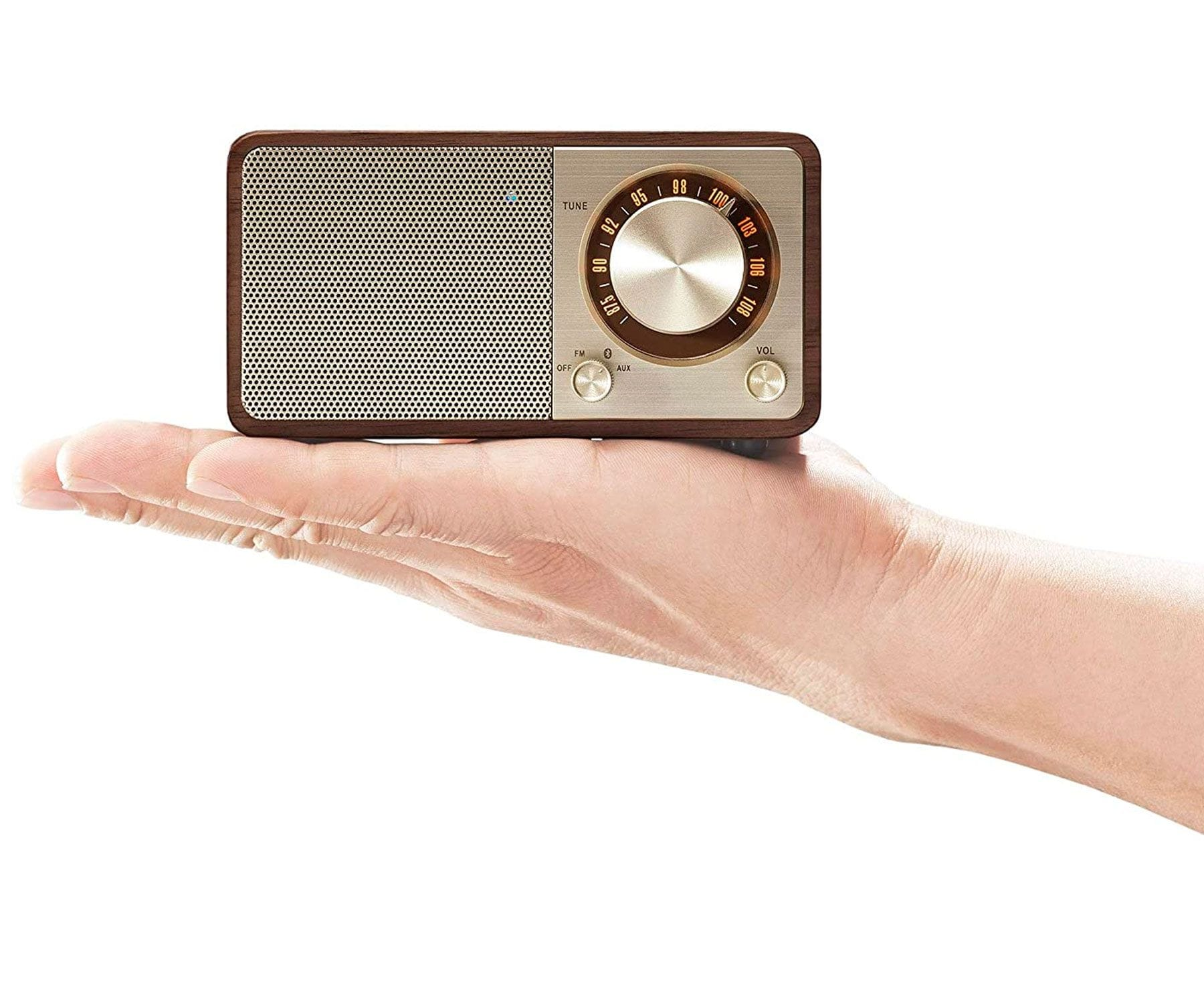 Małe drewniane radio retro trzymane w dłoni. Białe tło.