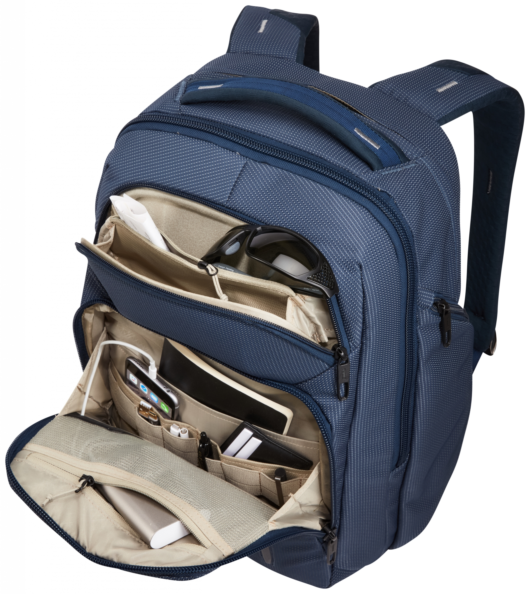 Ein blauer Rucksack geöffnet. Der Inhalt umfasst Stifte, Telefon, Brille und Tablet.
