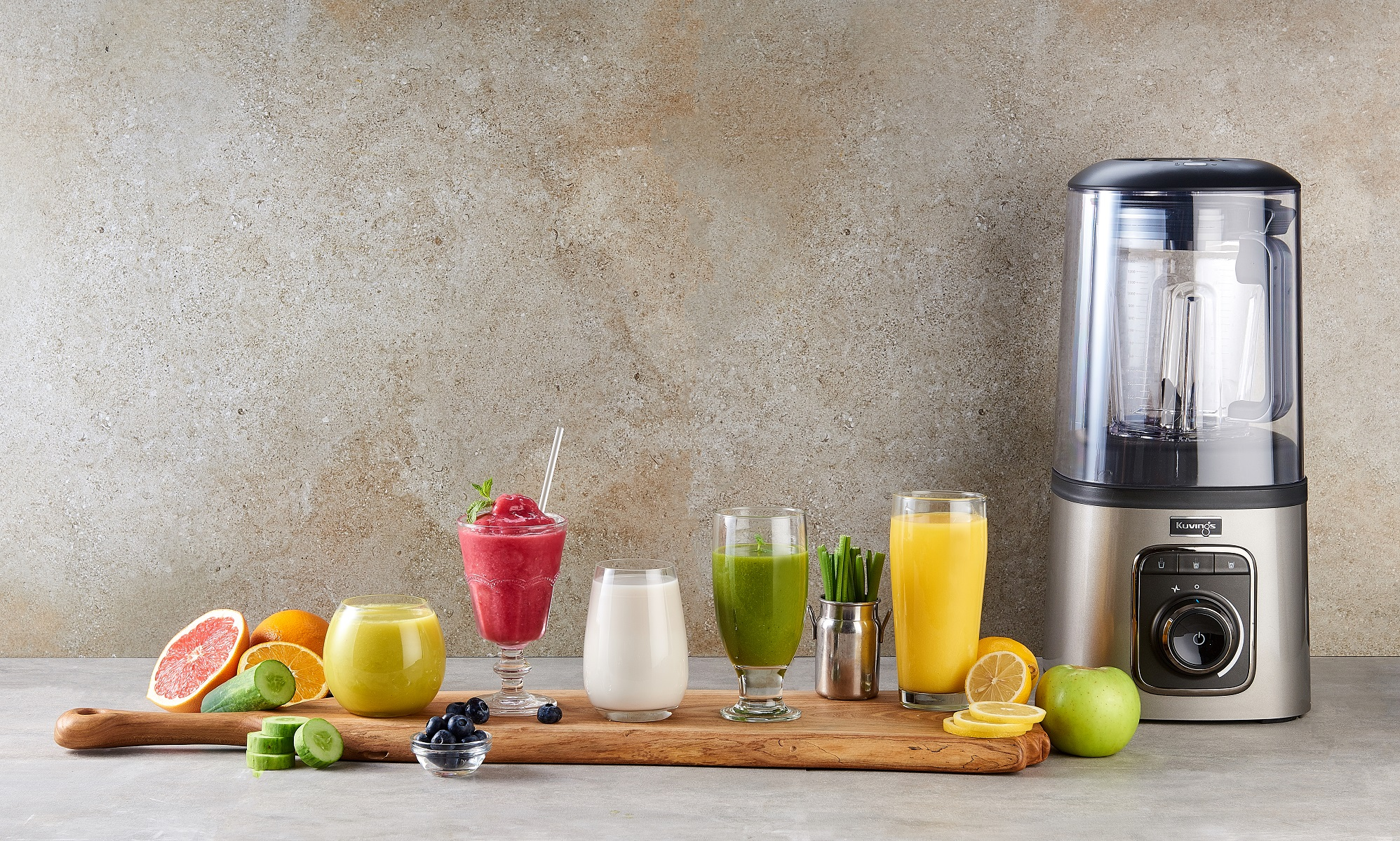 Blender z różnymi szklankami smoothie i świeżymi owocami.