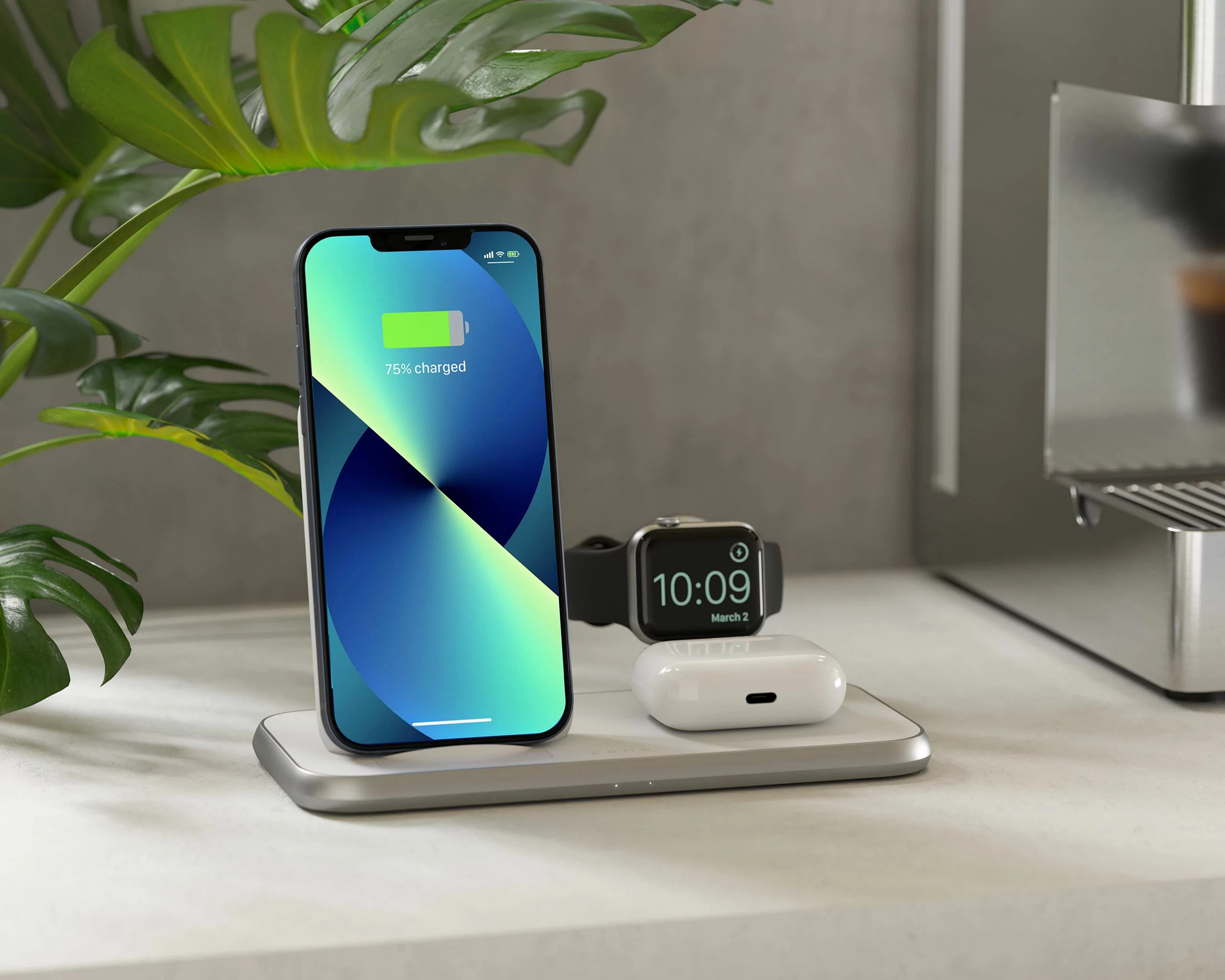 Ein Telefon, das auf einem kabellosen Ladepad aufgeladen wird, mit einer Uhr und Ohrhörern auf weißer Oberfläche.
