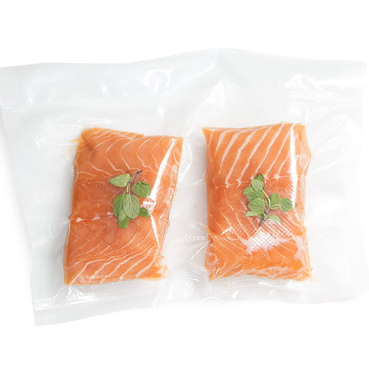 Zwei Lachsfilets in vakuumversiegelter Plastikverpackung mit Kräutern.