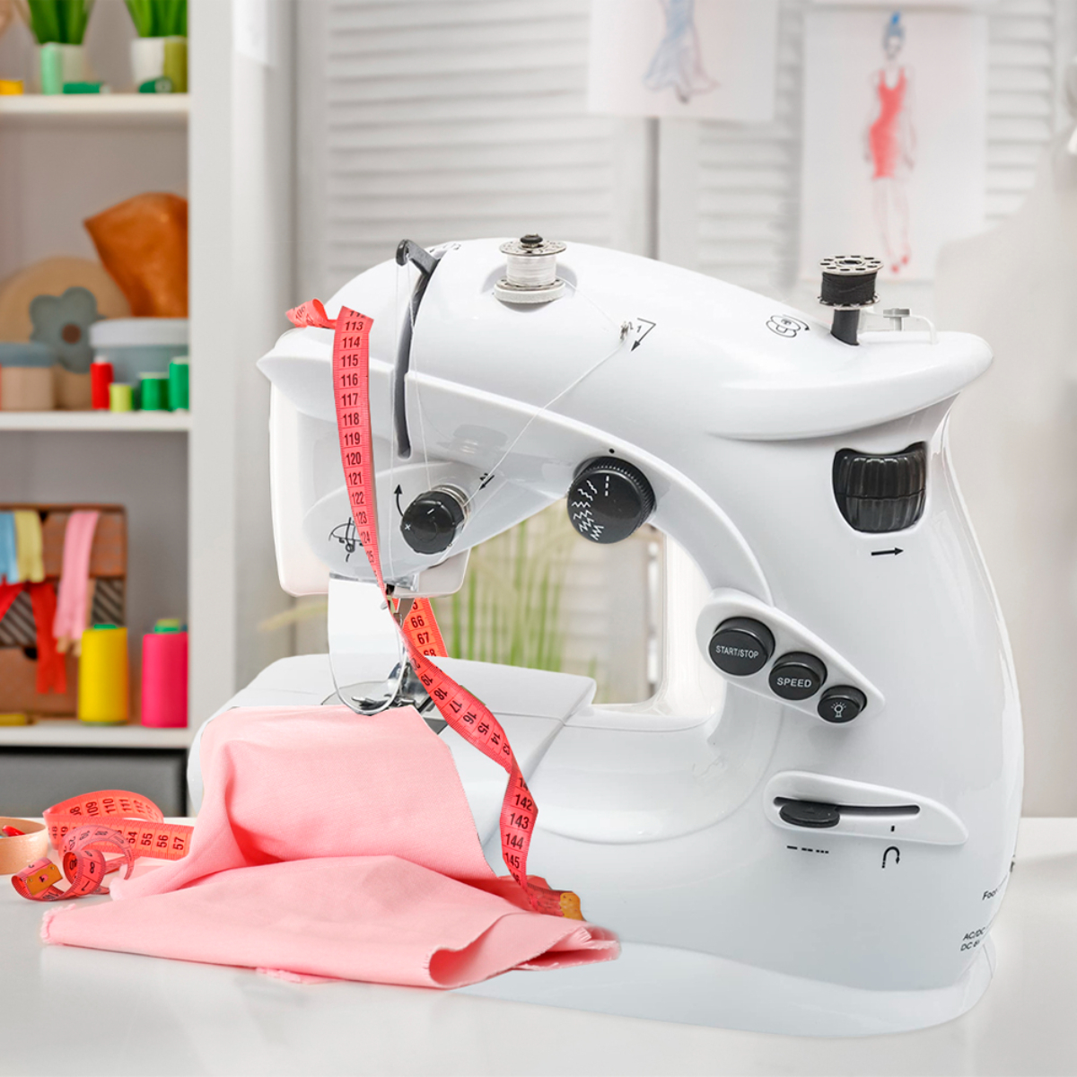 Máquina de coser blanca con tela rosa, cinta métrica en un escritorio blanco. Herramientas.
