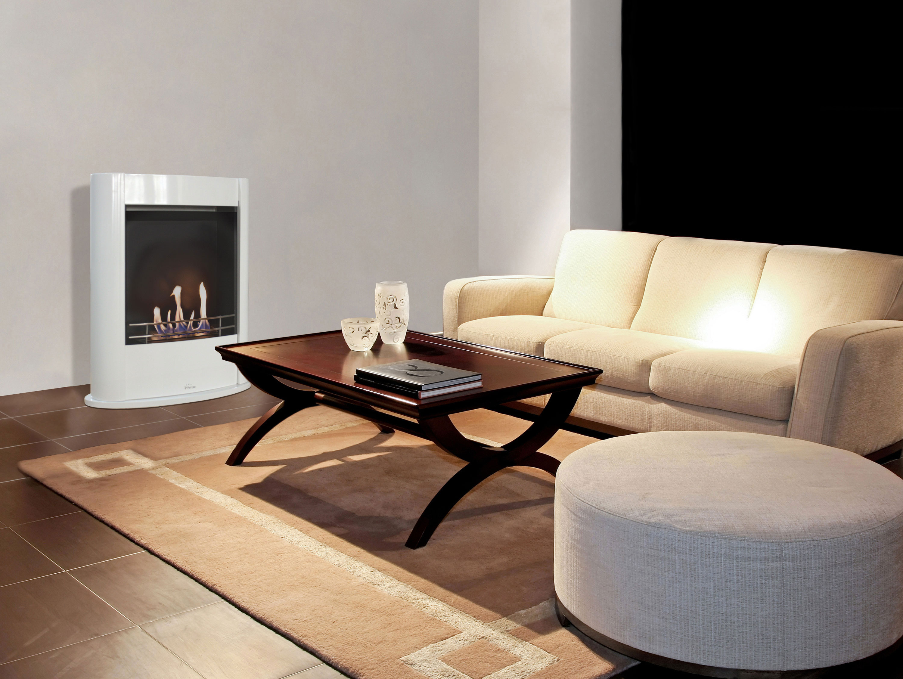 Chimenea en salón. Chimenea y muebles blancos. Mesa y alfombra de madera.