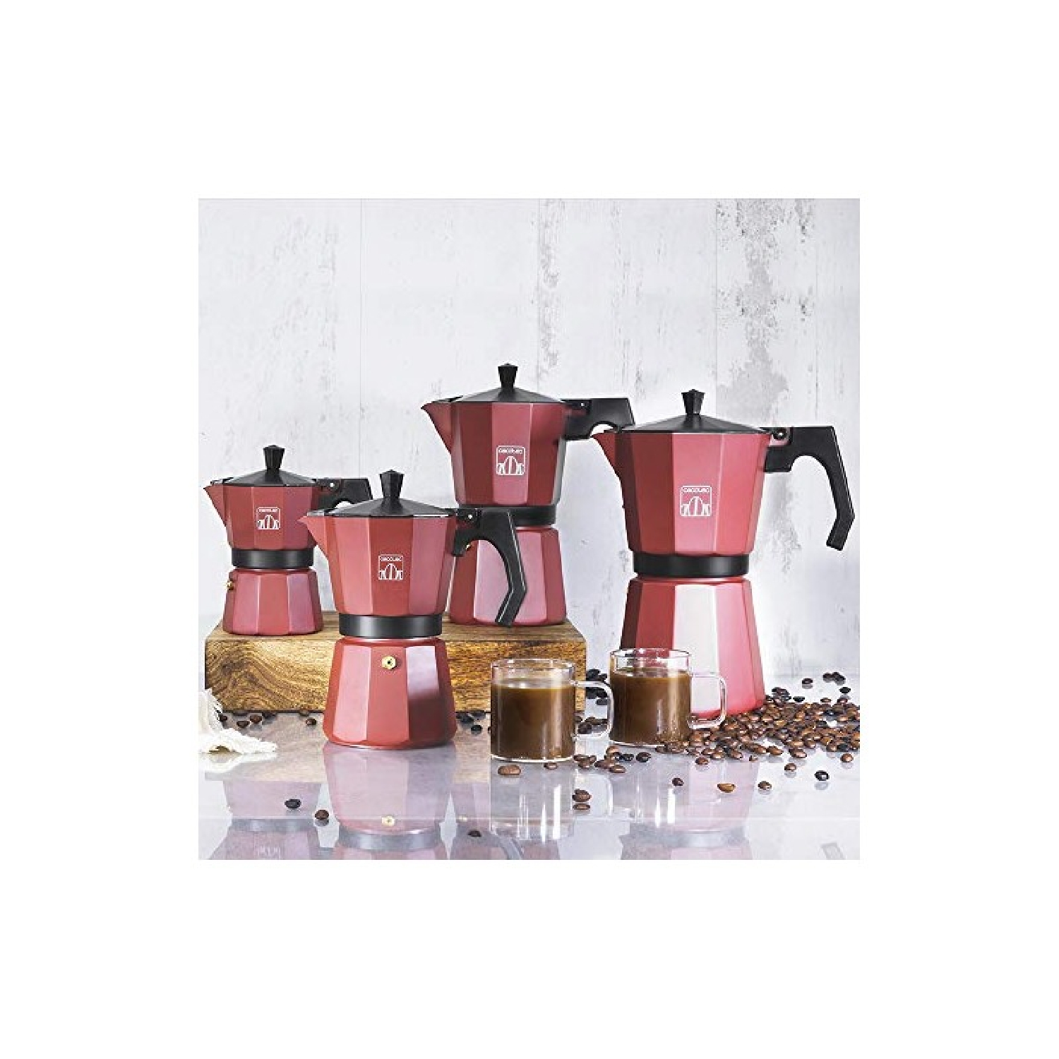 Varias cafeteras rojas de varios tamaños, con tazas de café y granos.