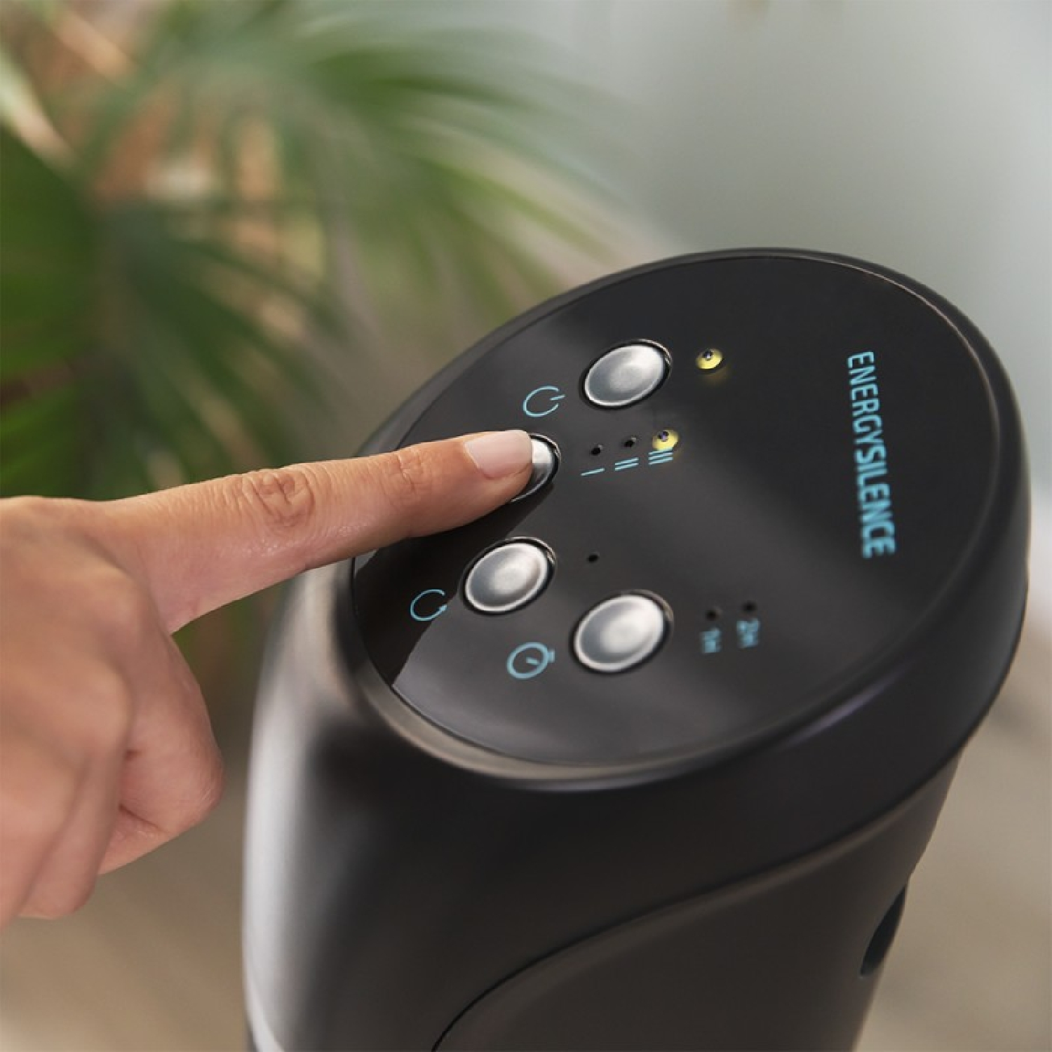 Ręka osoby naciskająca przycisk na czarnym panelu sterowania z napisem ENERGY SILENCE.
