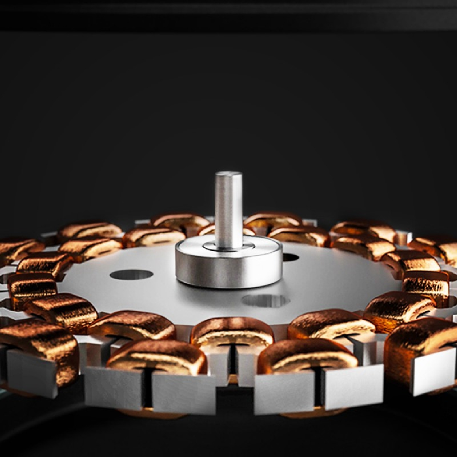 Zbliżenie obracającego się elementu silnika, pokazujące cewki miedziane i srebrną konstrukcję centralną.