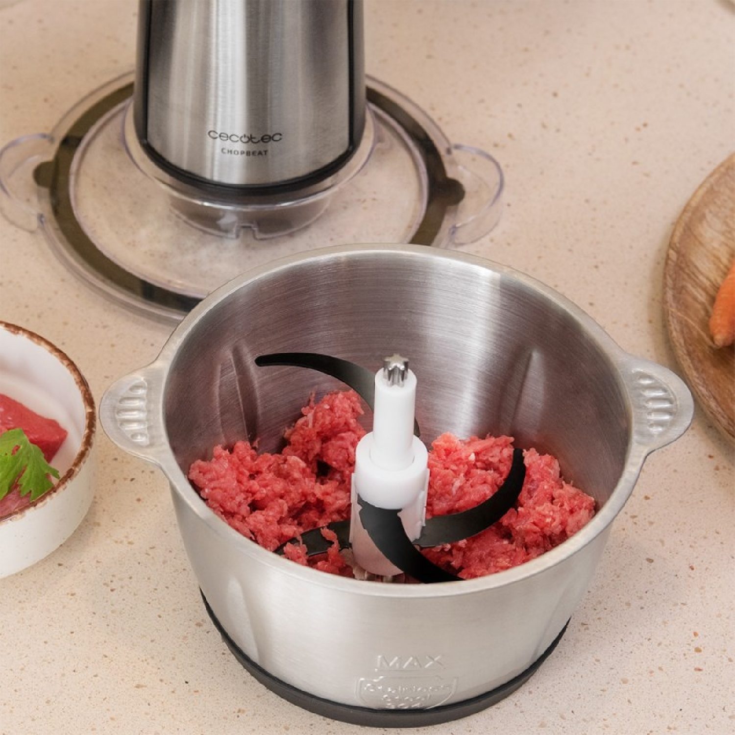 Silberner Zerkleinerer mit rotem Hackfleisch. Hackmesser sind schwarz und weiß.