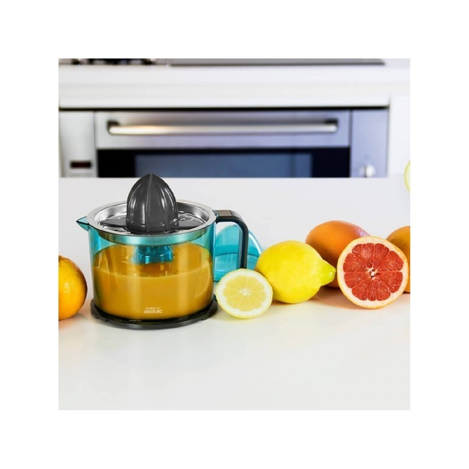 Exprimidor con zumo de naranja y fruta sobre una superficie blanca, fondo de cocina.