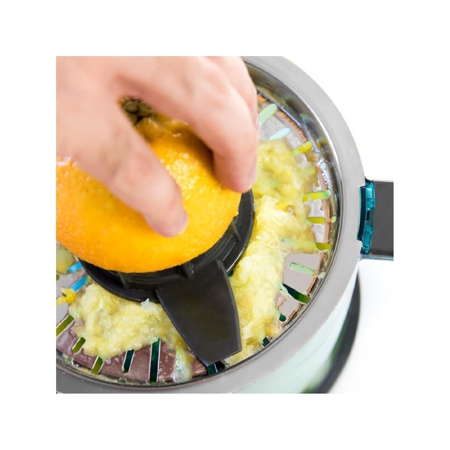 Mano exprimiendo media naranja en una exprimidora. Zumo de naranja extraído. Exprimidora plateada y negra.