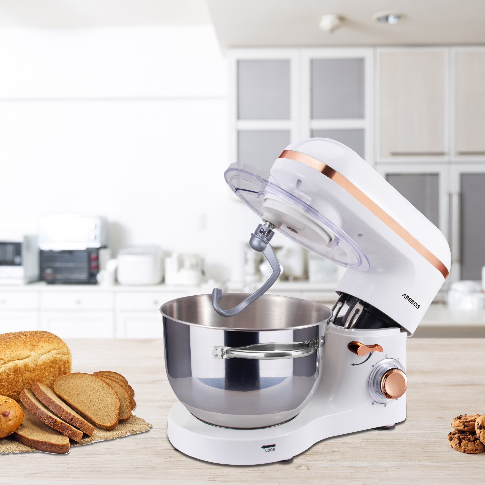 Weißer Standmixer mit roségoldenen Akzenten, Brot und Kekse auf dem Tisch.