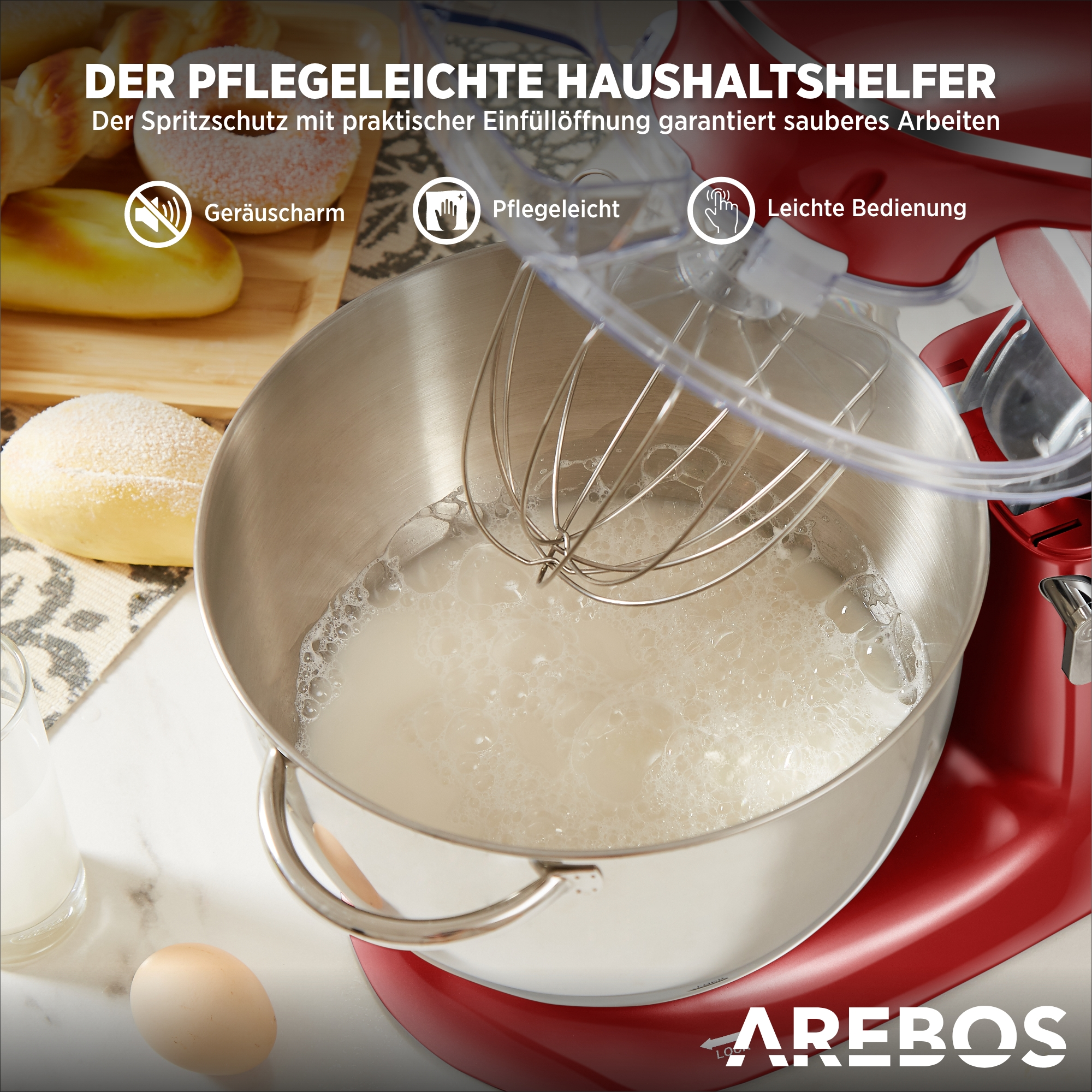 Roter und silberner Küchenmixer mit einer Rührschüssel mit Flüssigkeit und einem Ei auf dem Tisch.
