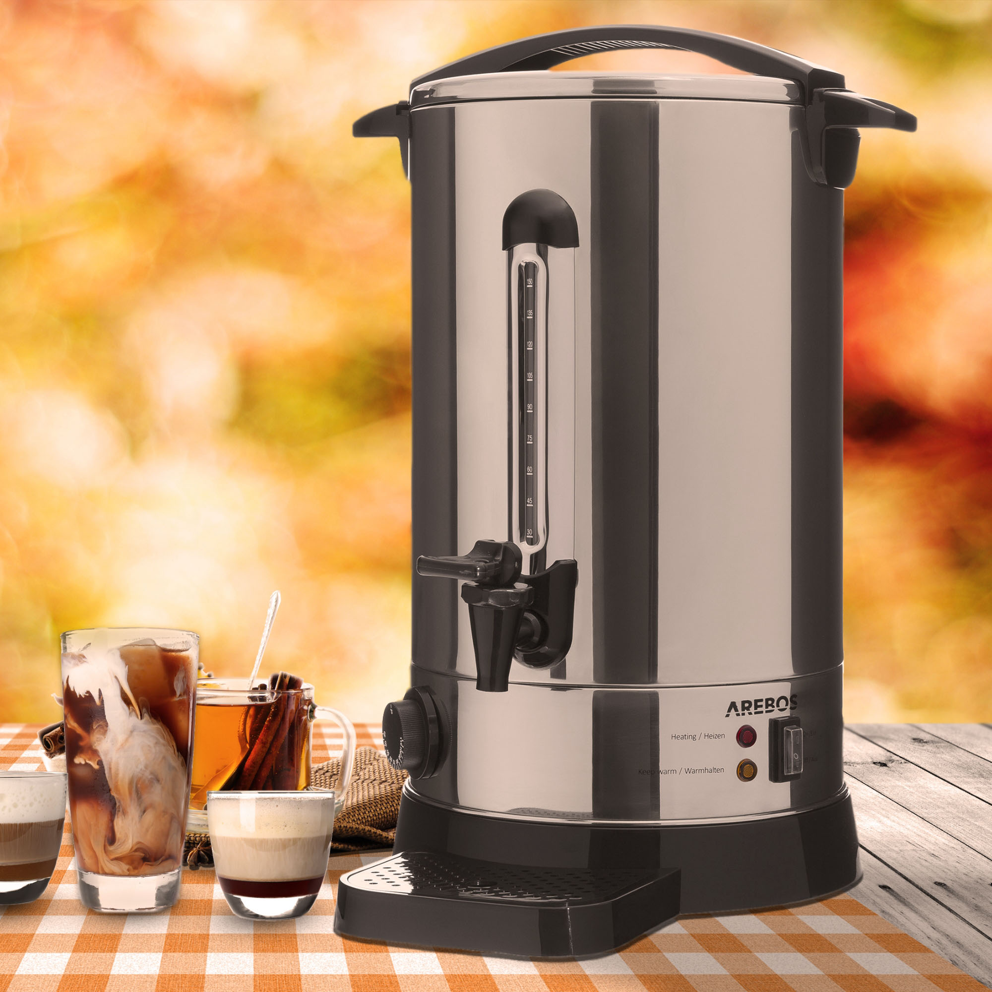 Silberne und schwarze Kaffee-Urne mit Kaffeegläsern. Karierte Tischdecke und Herbsthintergrund.
