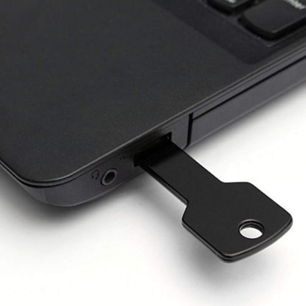 Schwarzer USB-Stick in einem Laptop. Der Stick hat Schlüsselform.