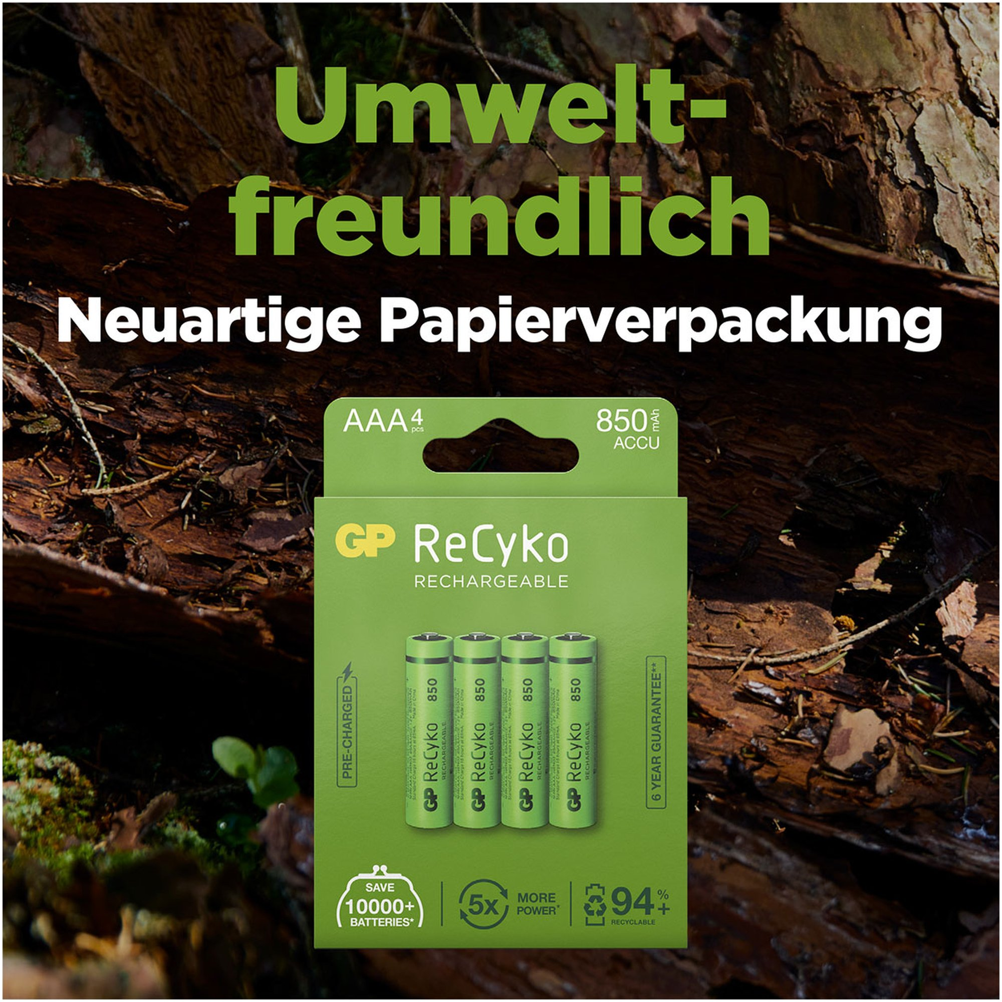 Grüne Batteriepackung mit deutschem Text, Batterien und Baumrindenhintergrund.