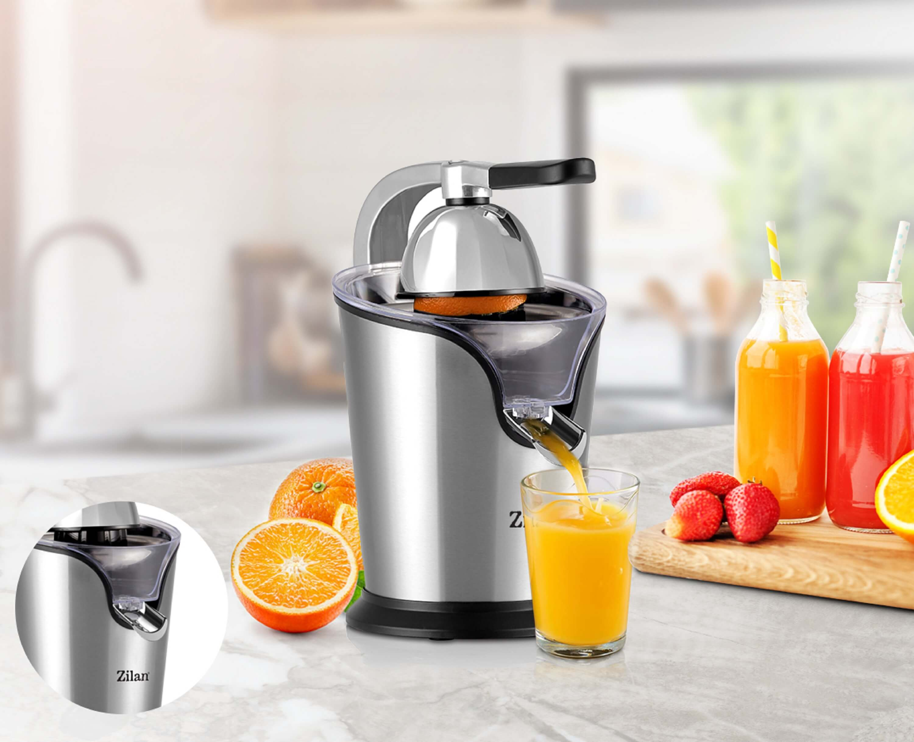 Entsafter mit Orangensaft, der in ein Glas gegossen wird. Orangen und Erdbeeren daneben.