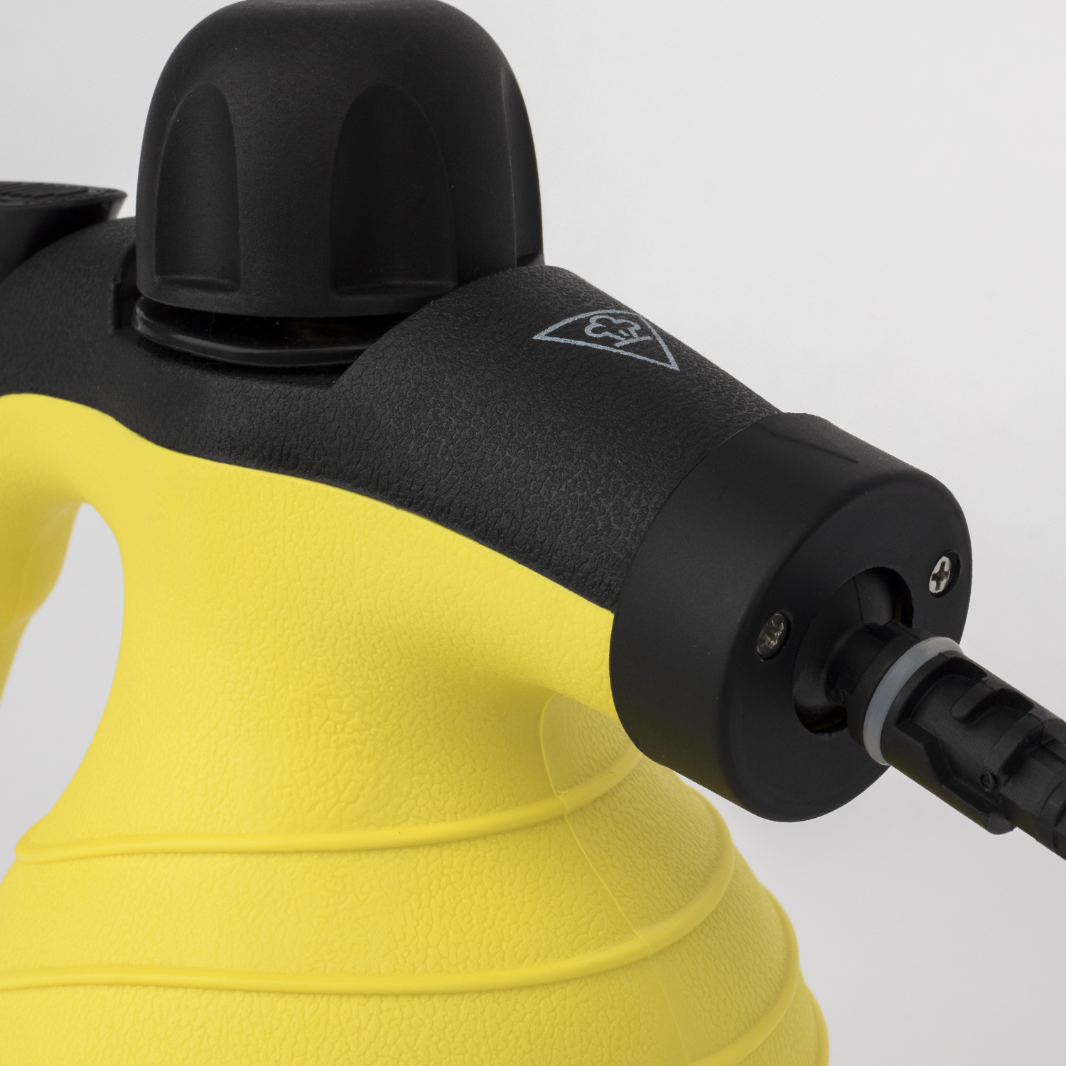 Zbliżenie dyszy żółtej i czarnej myjki parowej na białym tle.