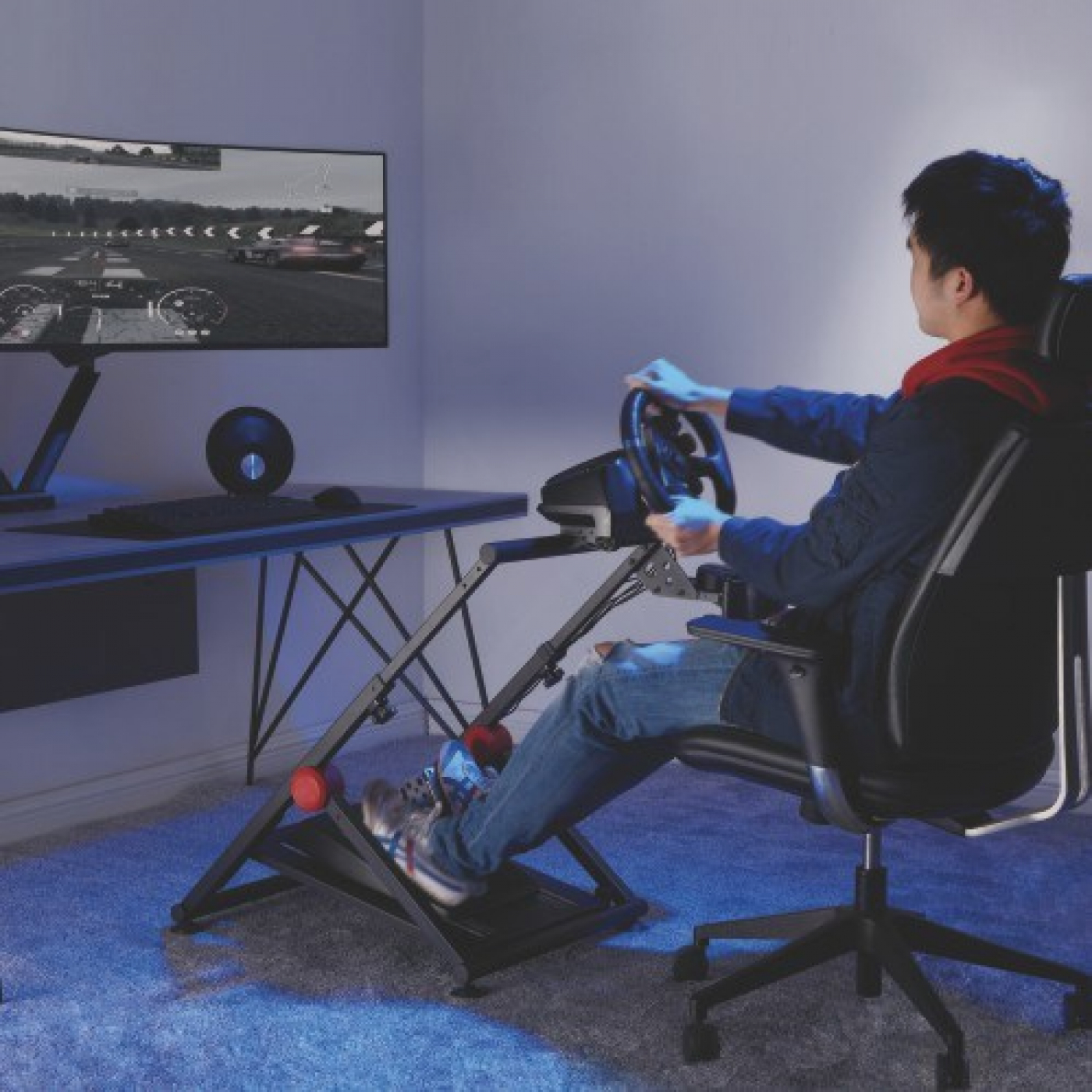 Mann spielt ein Rennspiel mit einem Lenkrad-Setup, sitzt in einem Gaming-Stuhl.
