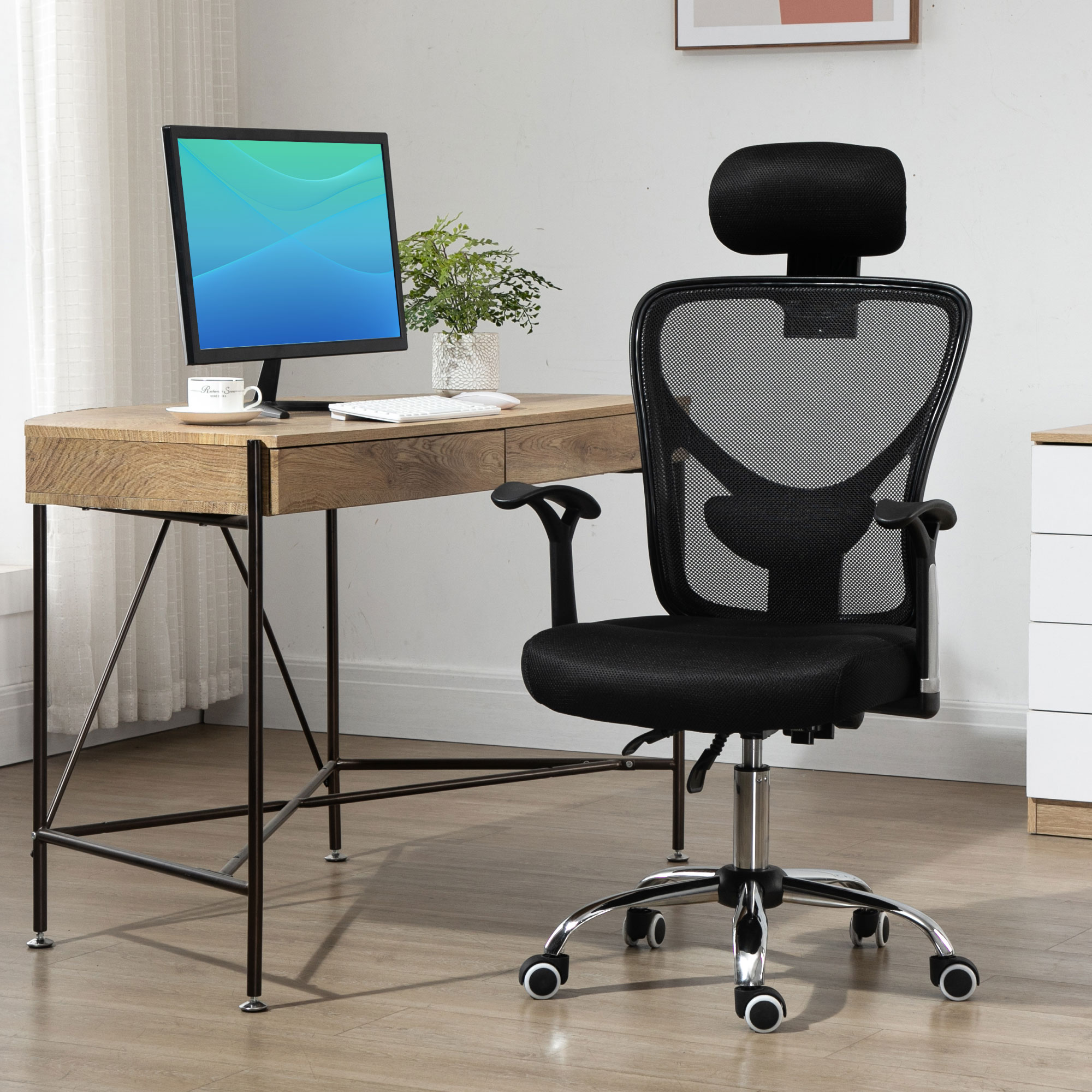 Oficina con una silla negra y un escritorio de madera con un monitor. El fondo es claro.