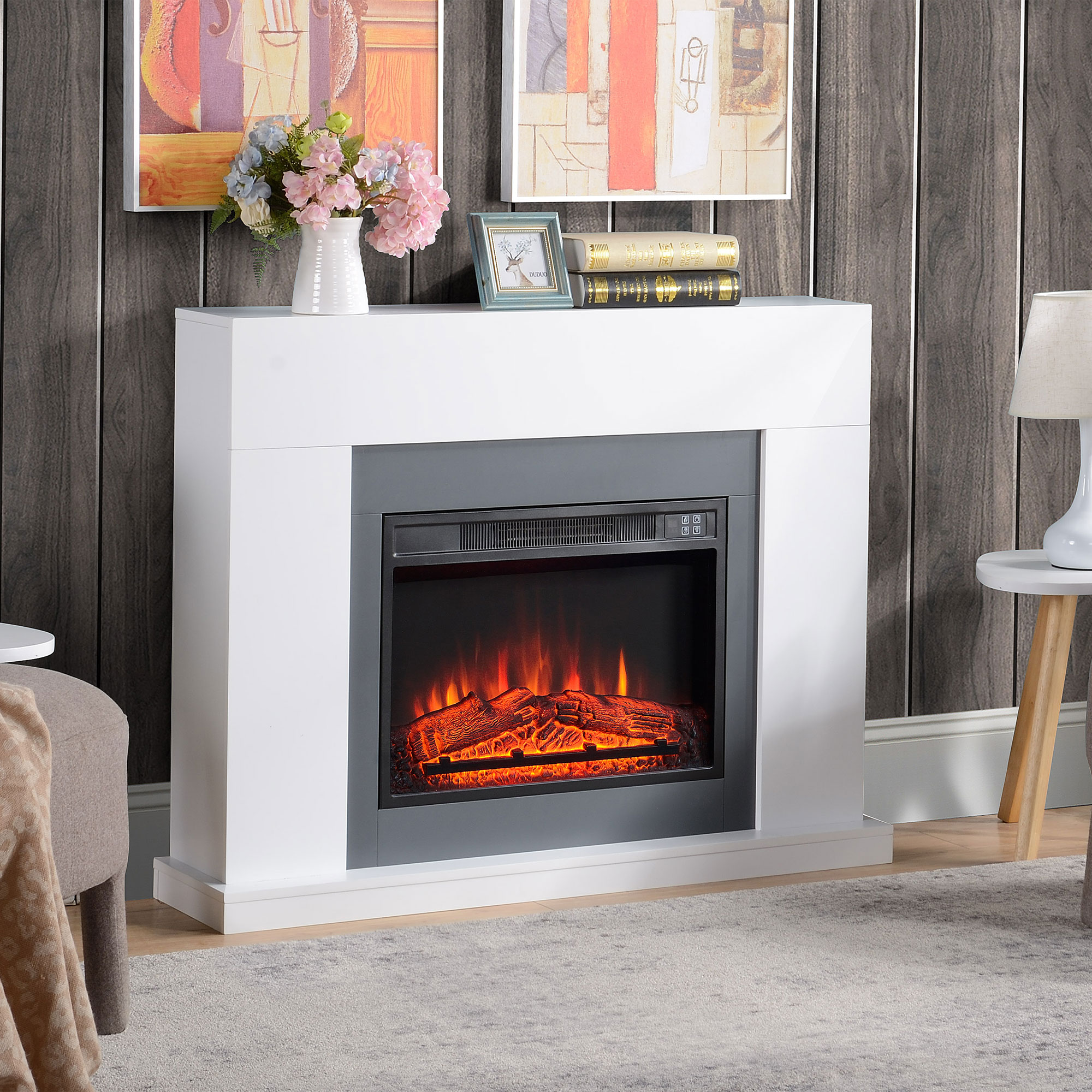 Chimenea eléctrica blanca. Tiene un hogar negro con efecto de fuego realista. Una pared gris al fondo.